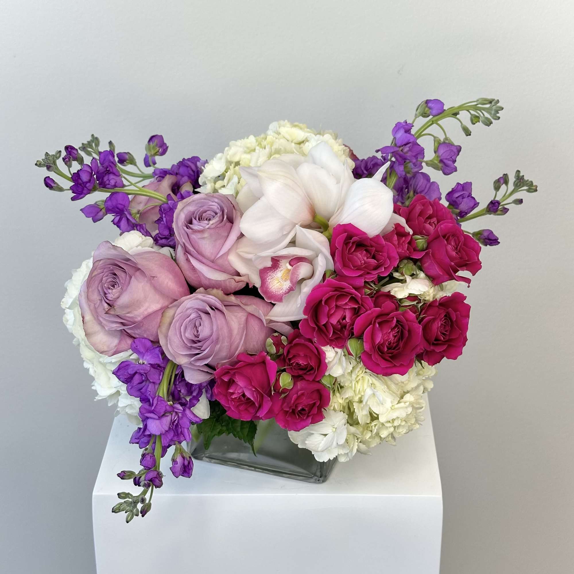 Bouquet of pink and white flowers in a square glass vase