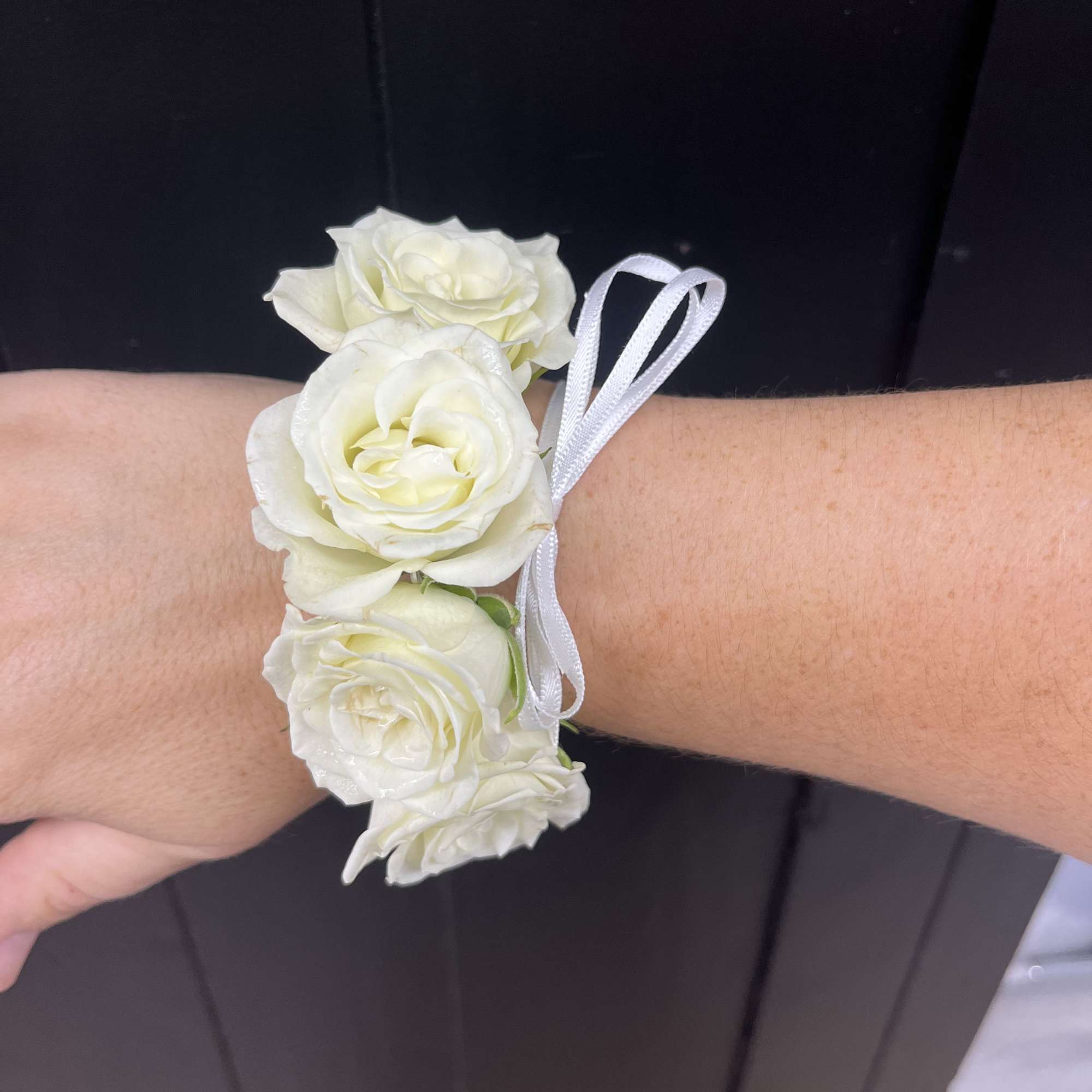 White rose wrist corsage with a satin ribbon tie
