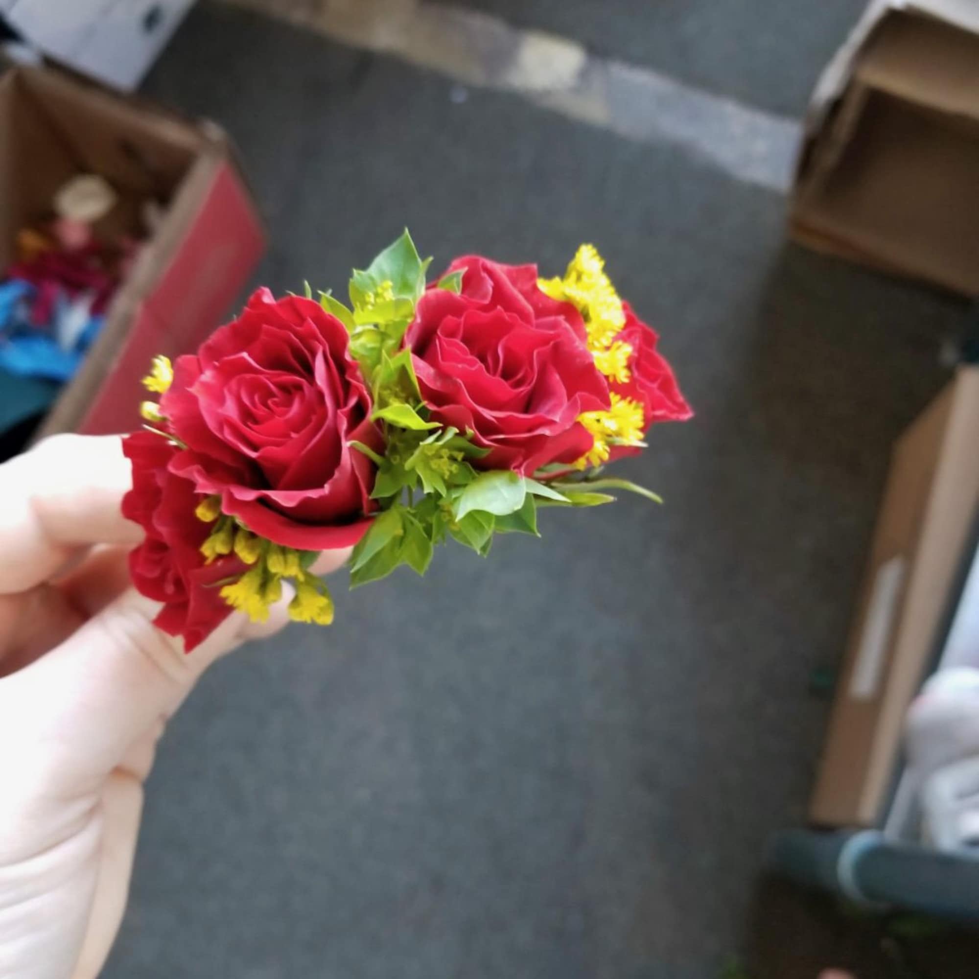 Small red rose corsage with yellow filler flowers