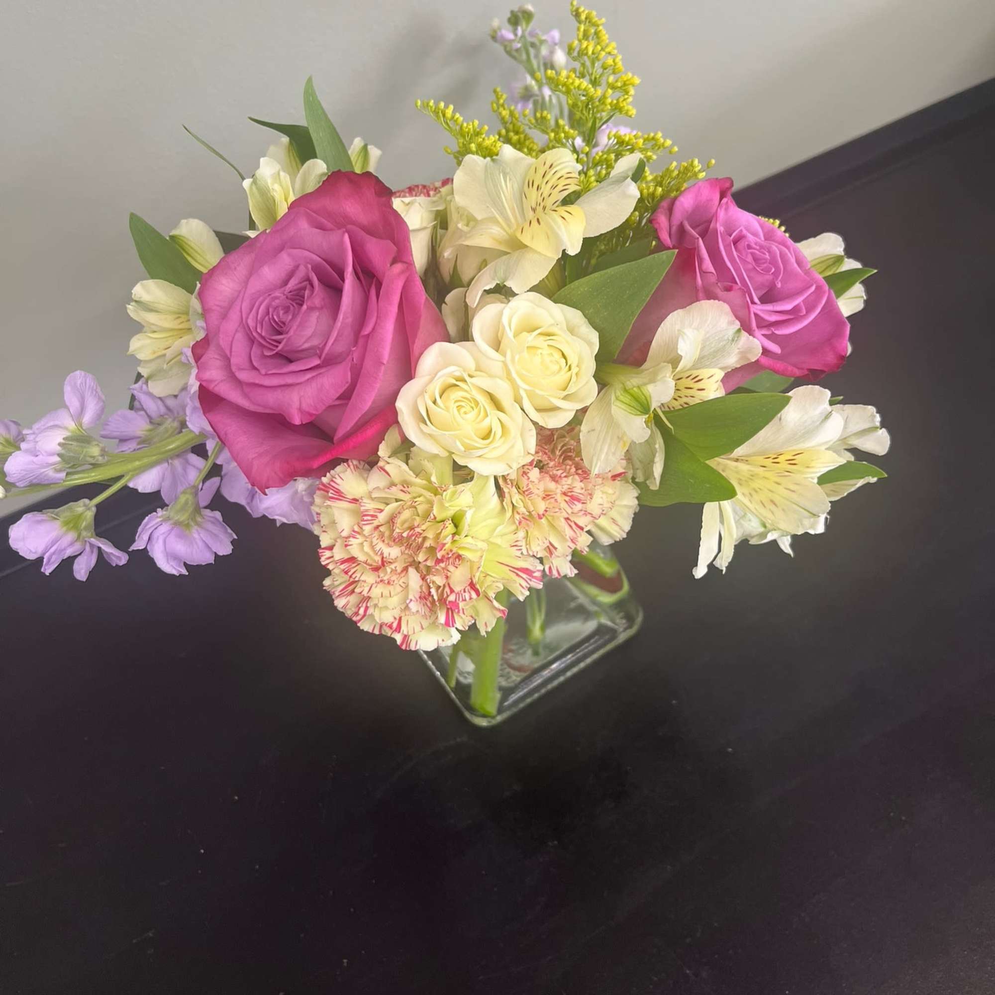 Bouquet of pink and cream roses with alstroemeria in a glass vase