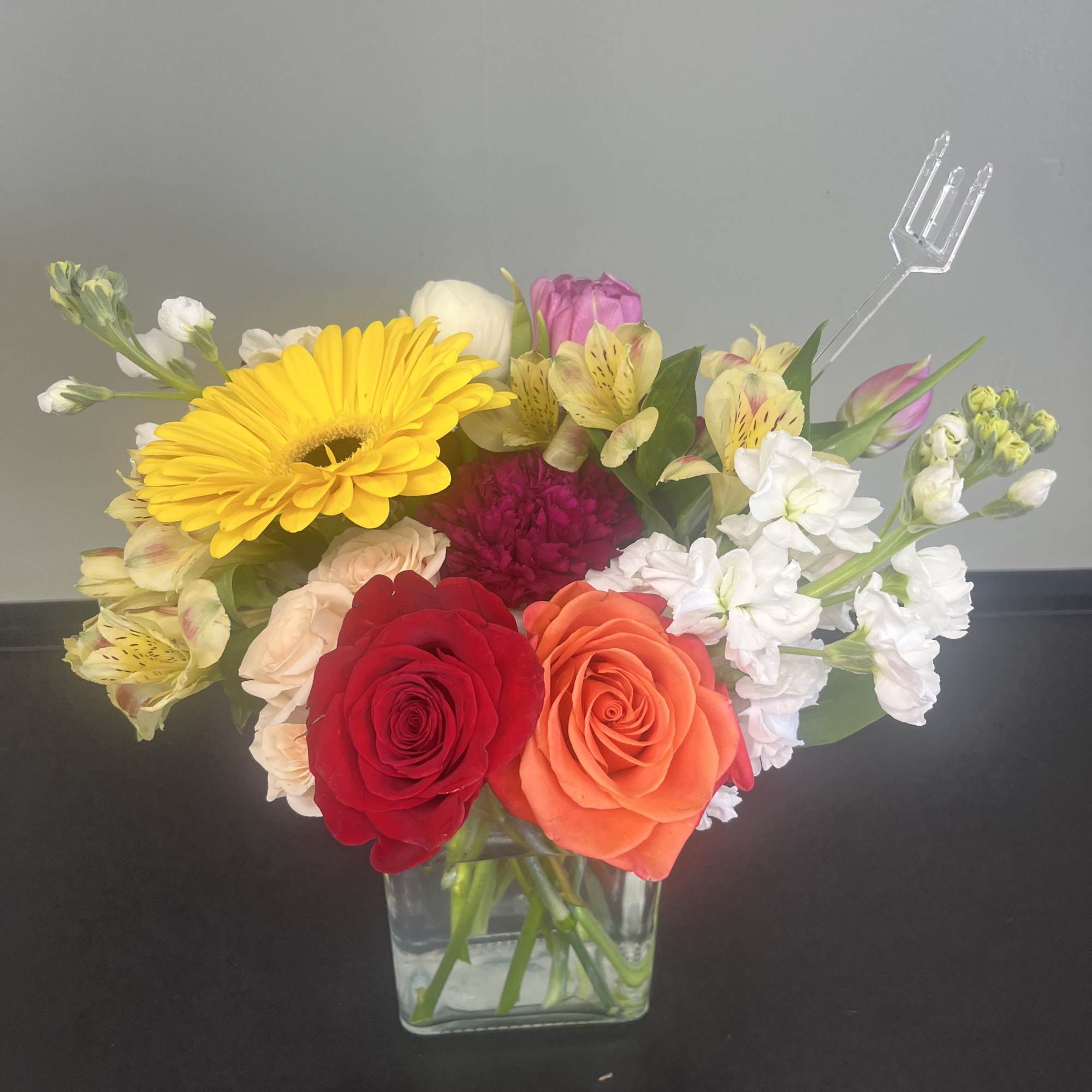 Mixed bouquet of roses, gerbera daisies, and alstroemeria in a glass vase