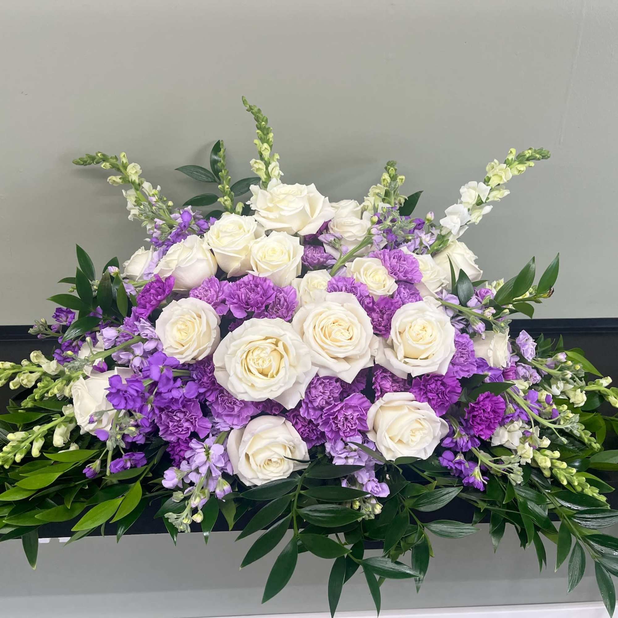 White roses and purple flowers arranged in a low centerpiece