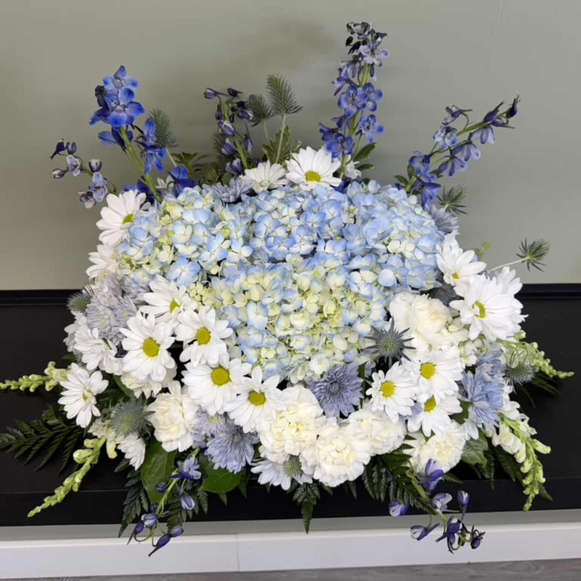 Blue and white floral arrangement with daisies and hydrangeas