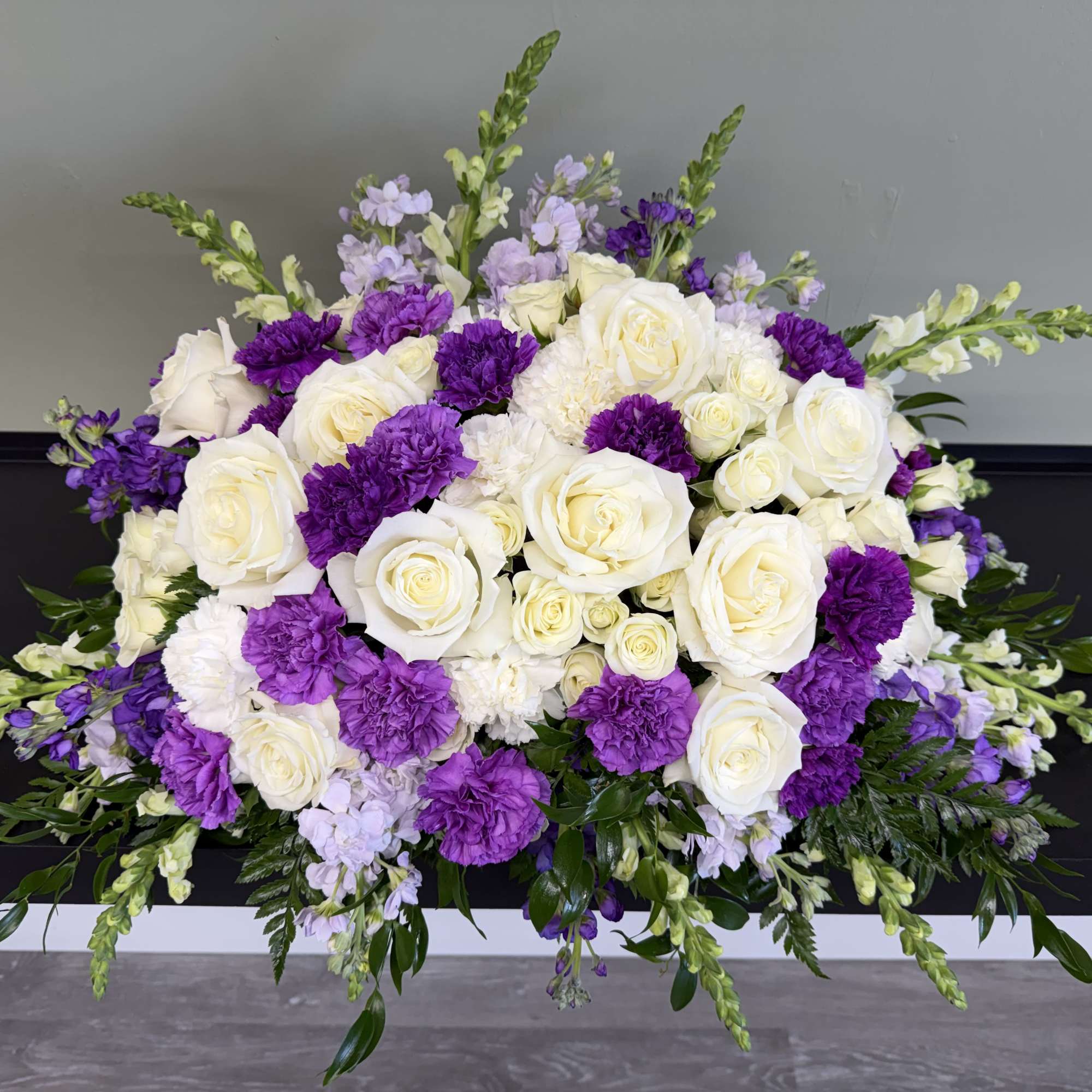 White roses and purple carnations in a low floral arrangement