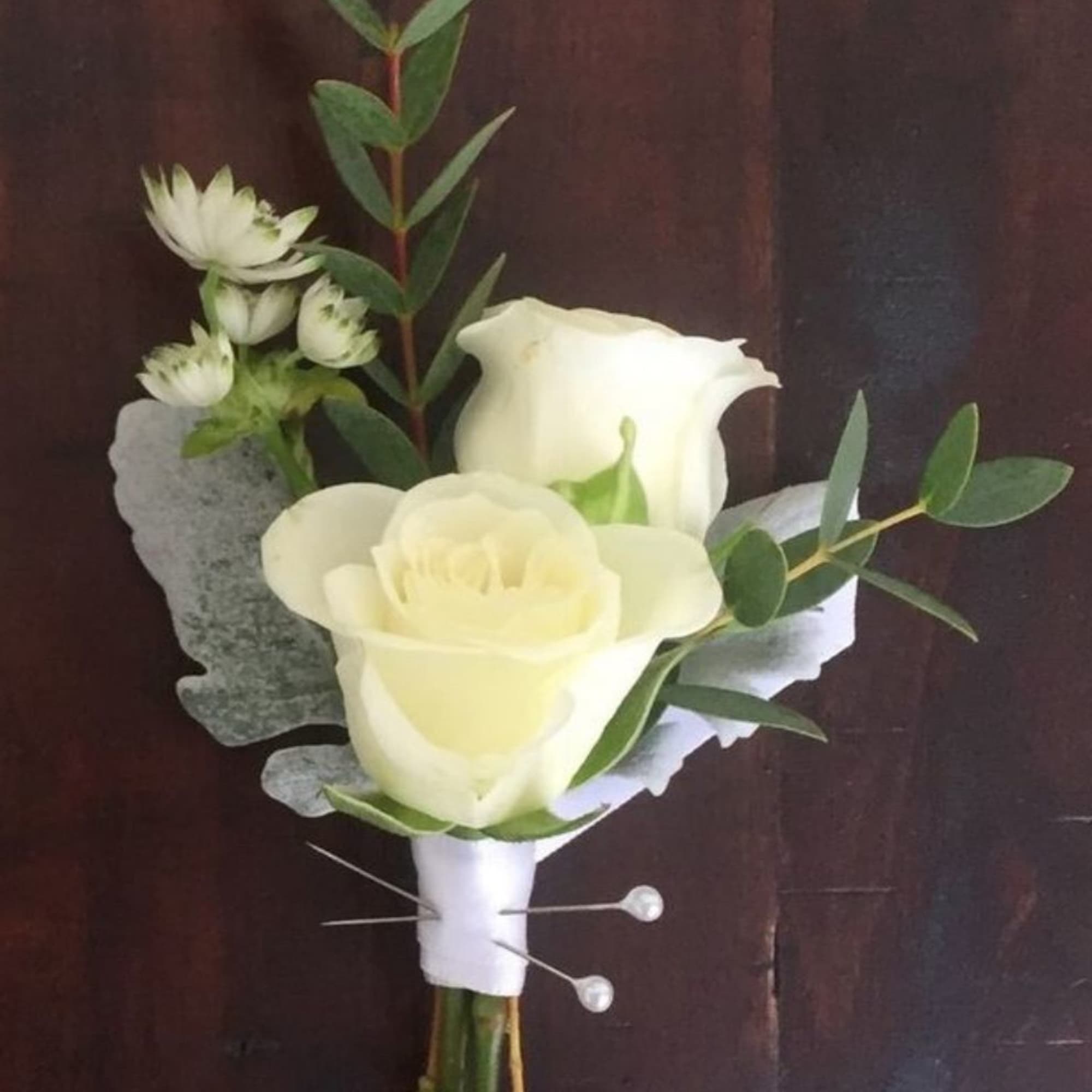 White rose and calla lily boutonniere with greenery