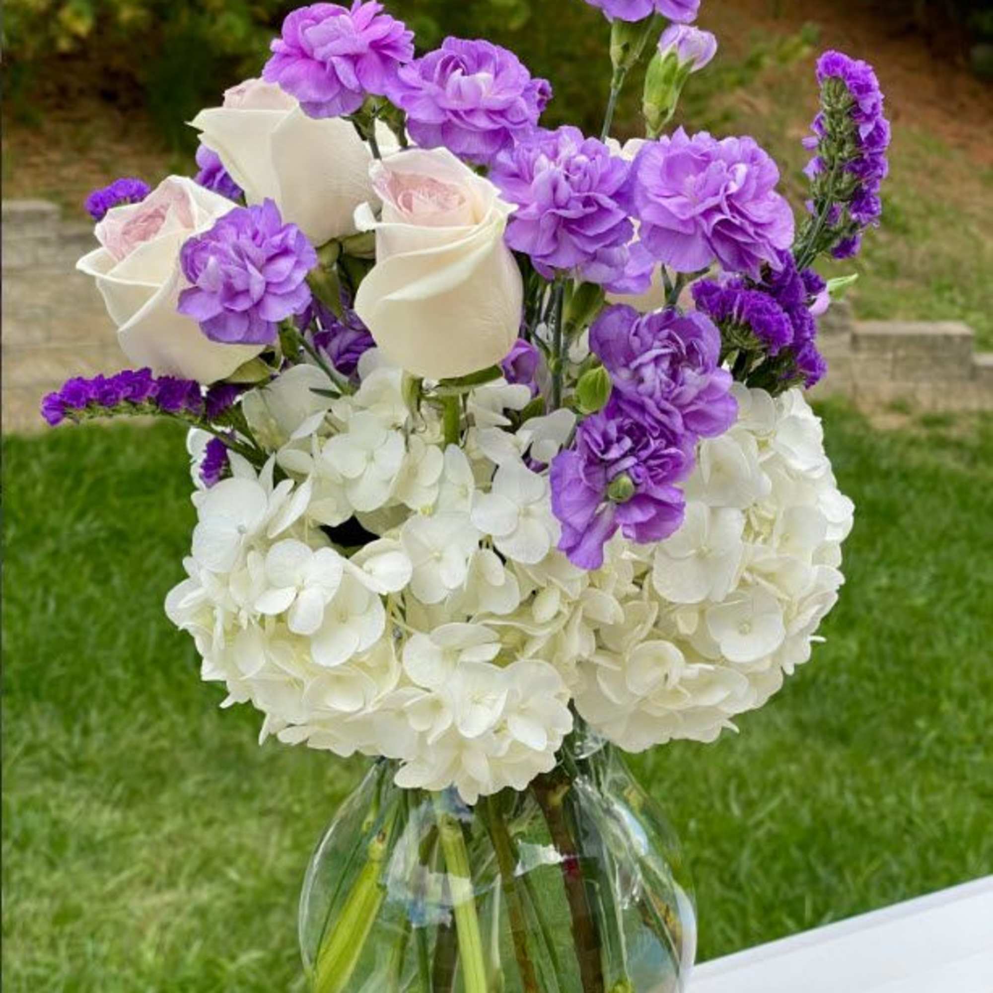 This elegant bouquet features a soft blend of white hydrangeas, creamy roses
