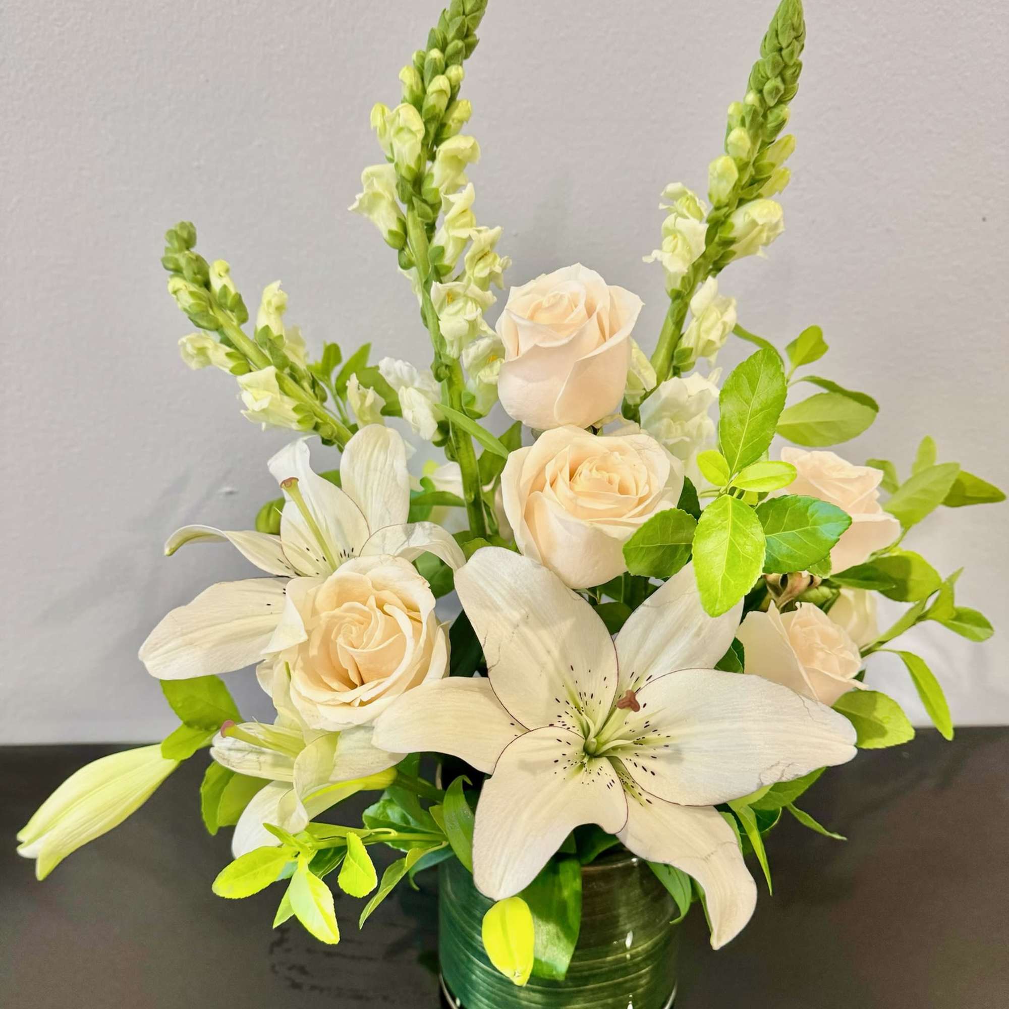 Cream roses and white lilies in a glass vase