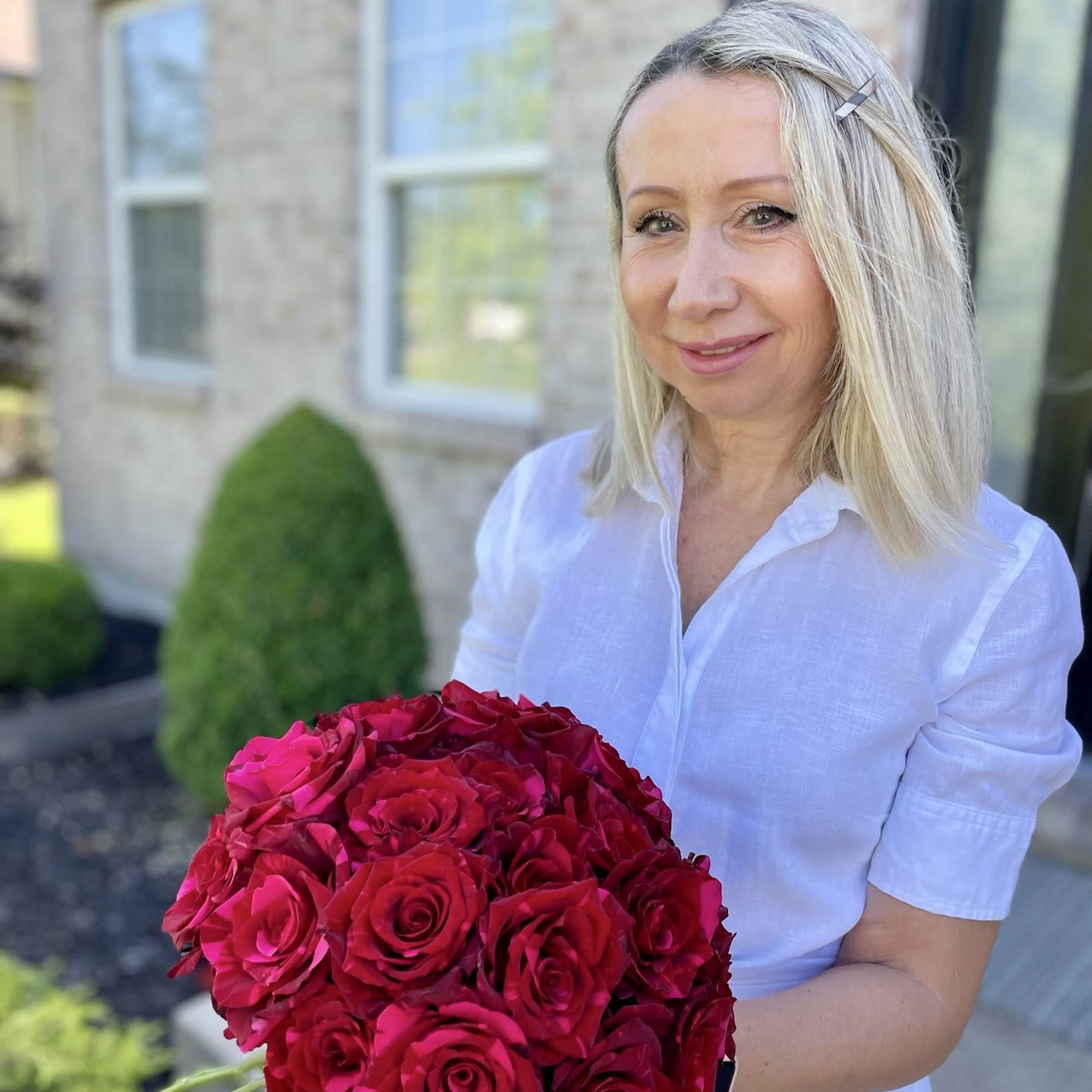 Woman holding a large bouquet of bright pink roses