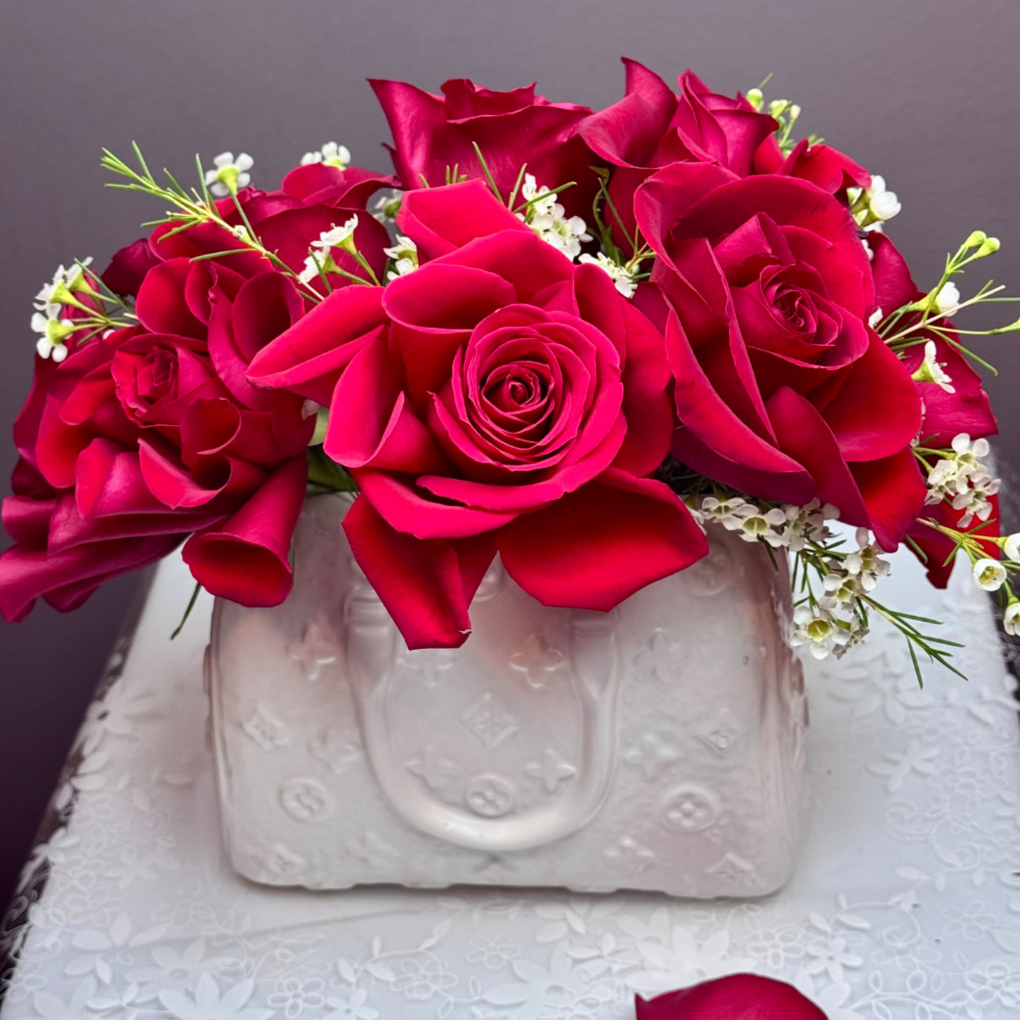 Pink rose bouquet in a white embossed vase