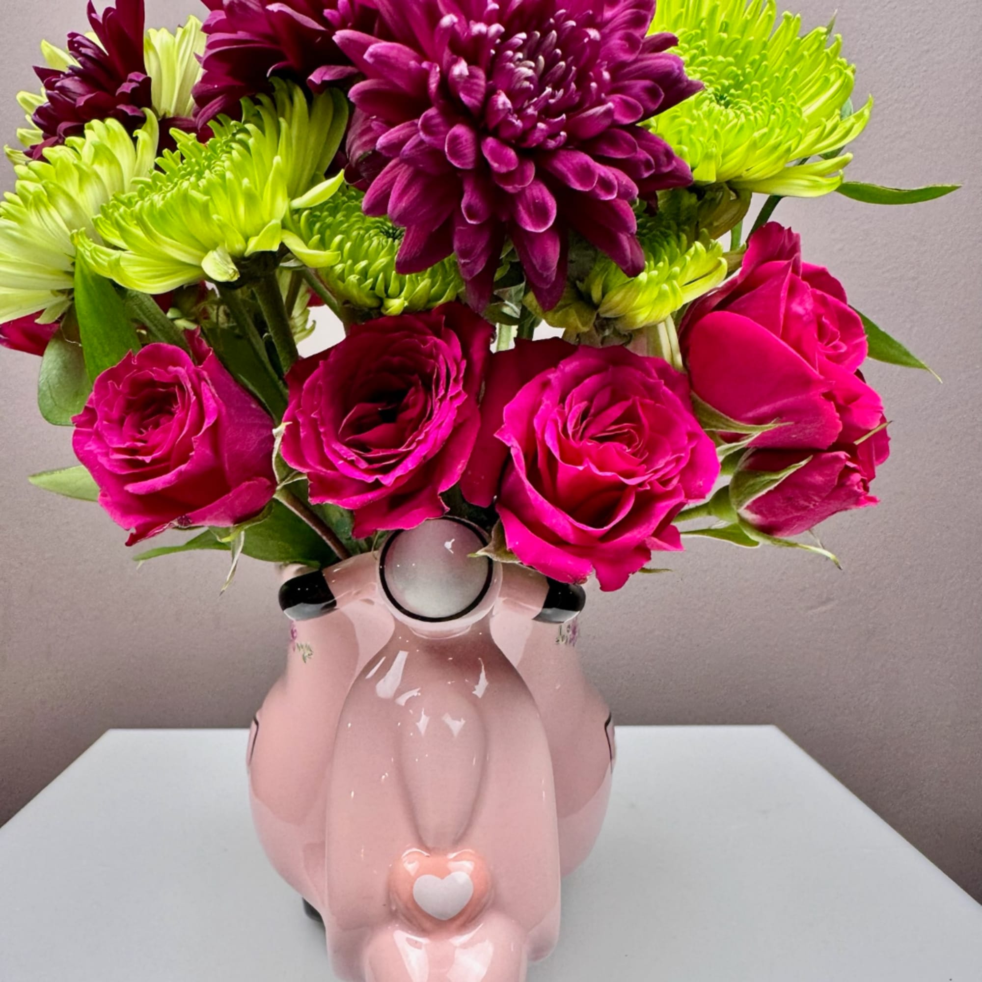Pink roses and purple-green chrysanthemums in a pink ceramic vase