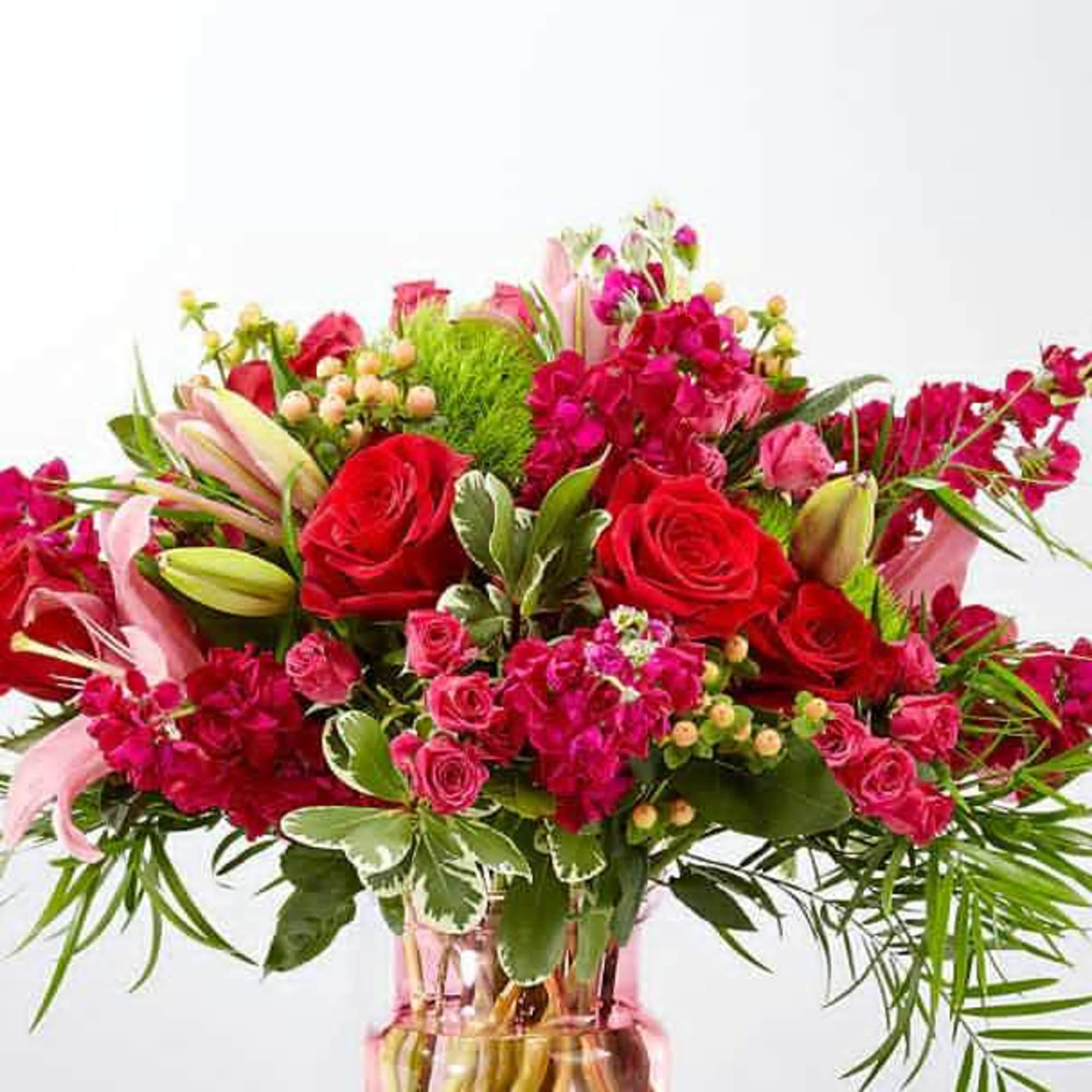 Bouquet of red roses and pink lilies in a glass vase