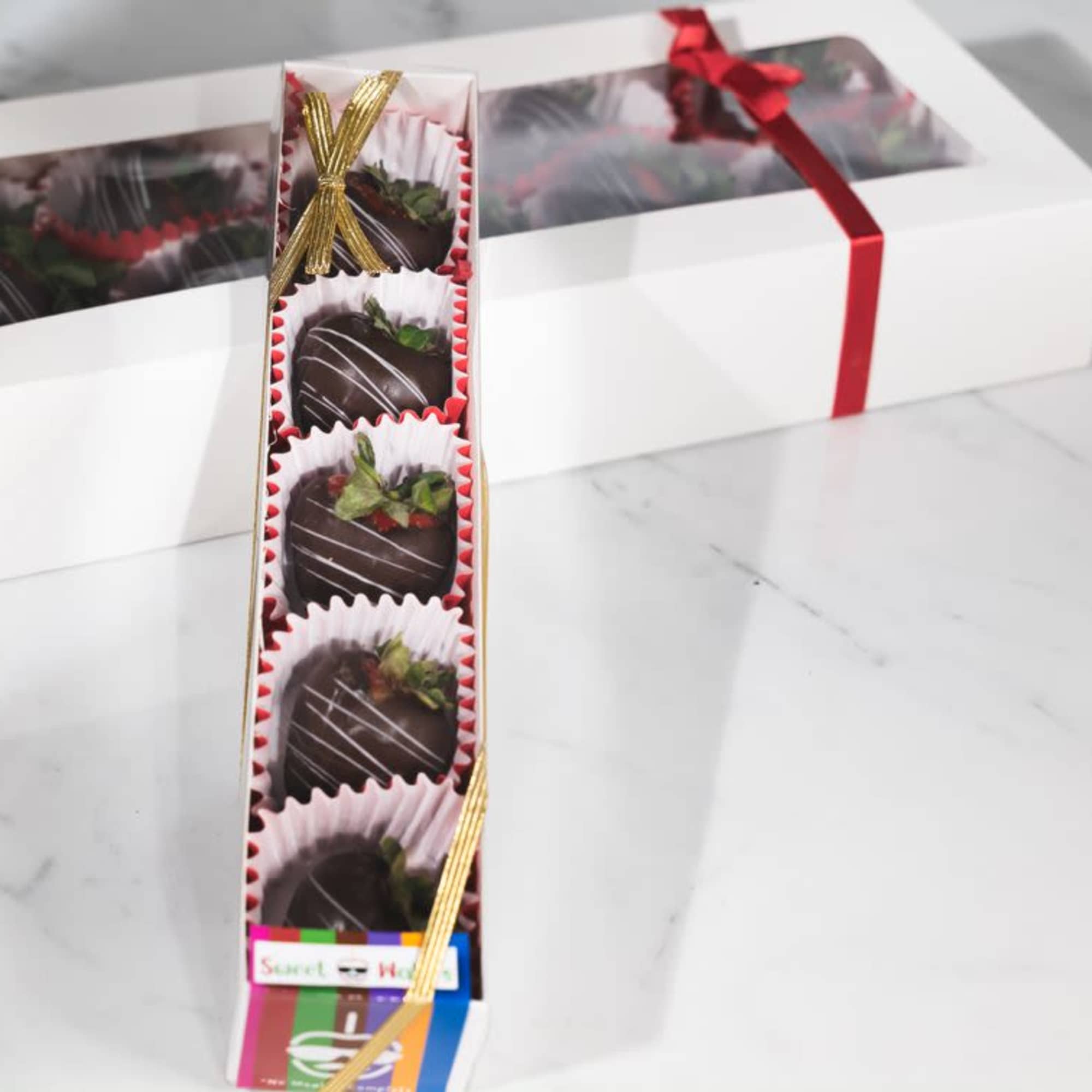 Box of chocolate-covered strawberries with ribbon ties