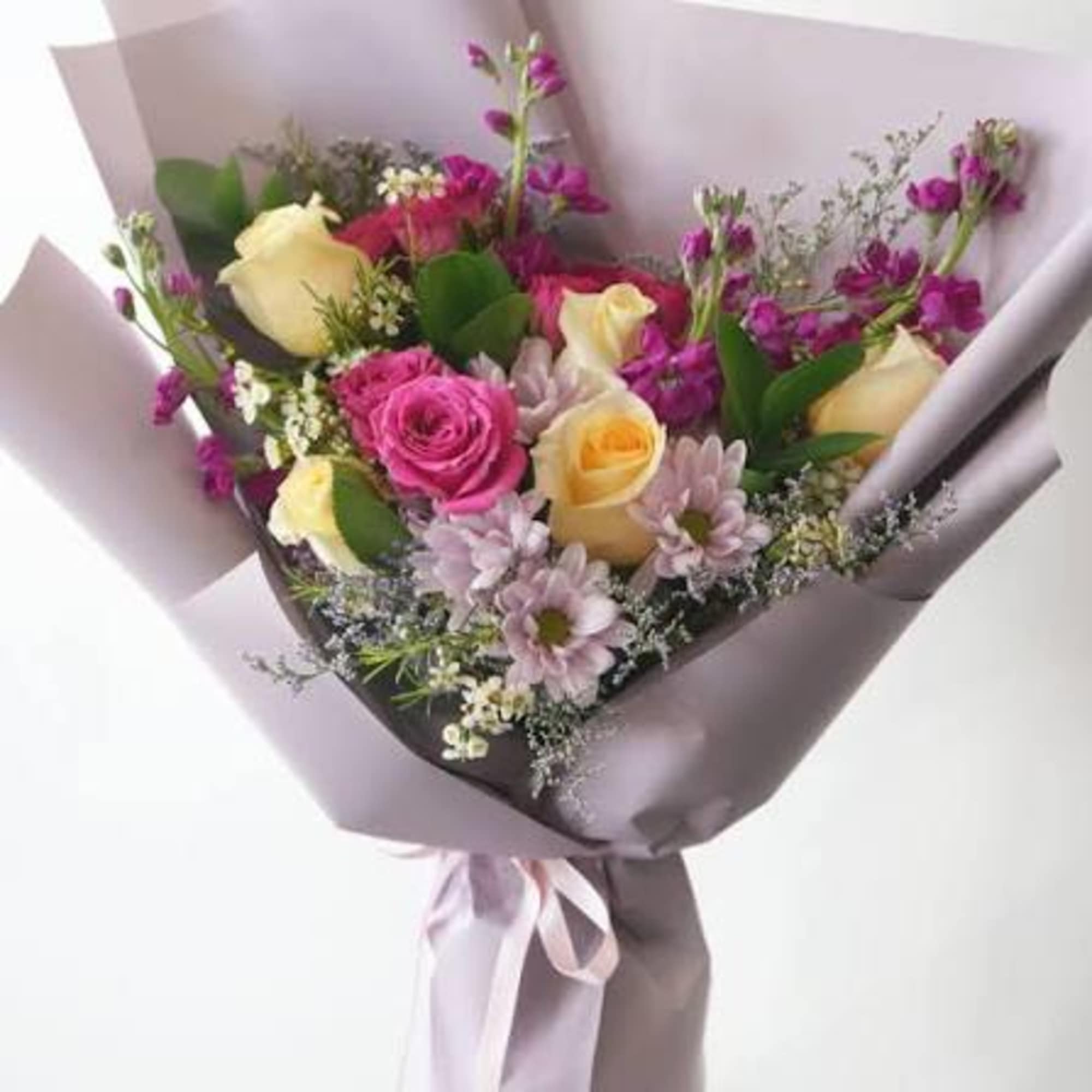 A playful mix of blush, berry, and soft lilac blooms wrapped in