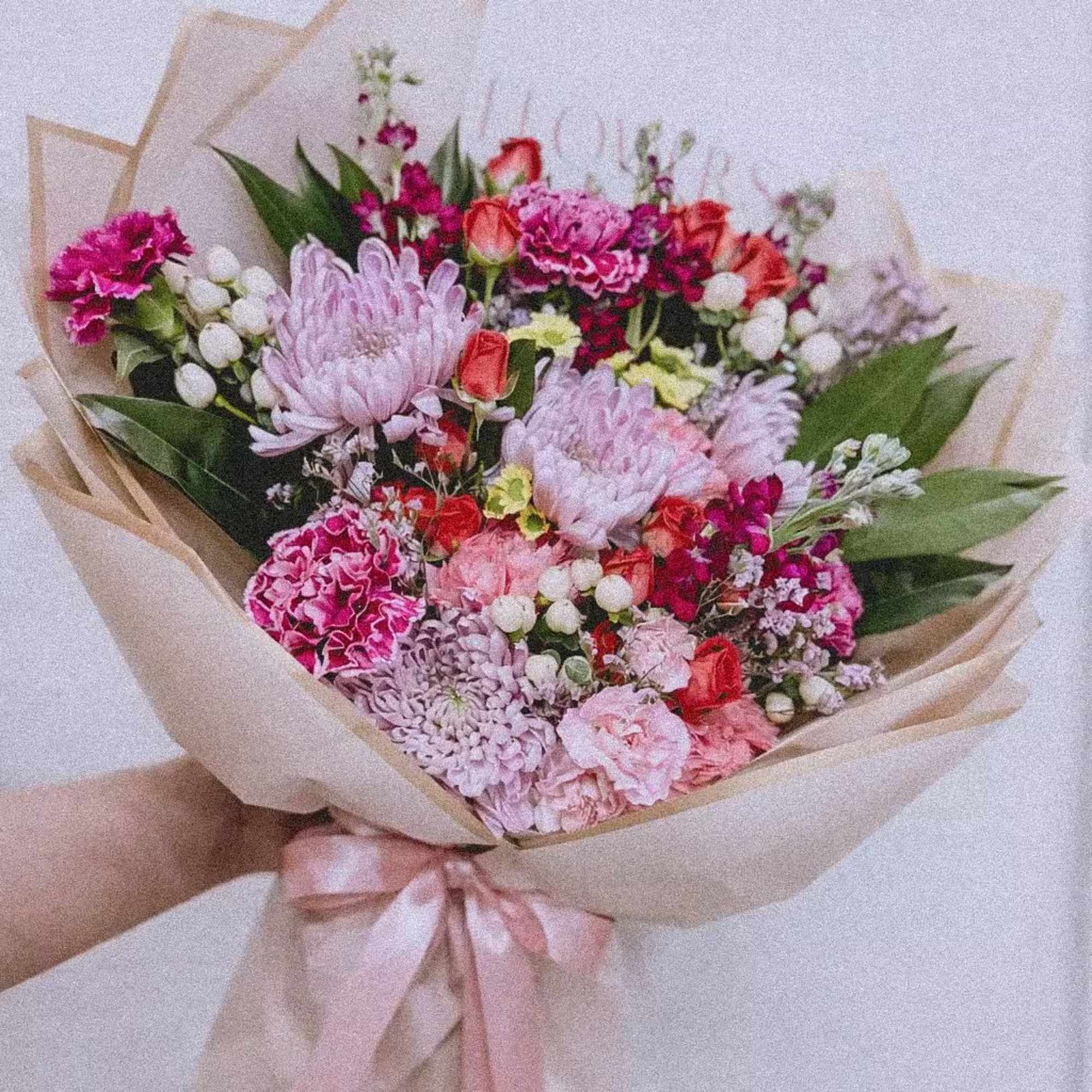A playful mix of blush, berry, and soft lilac blooms wrapped in
