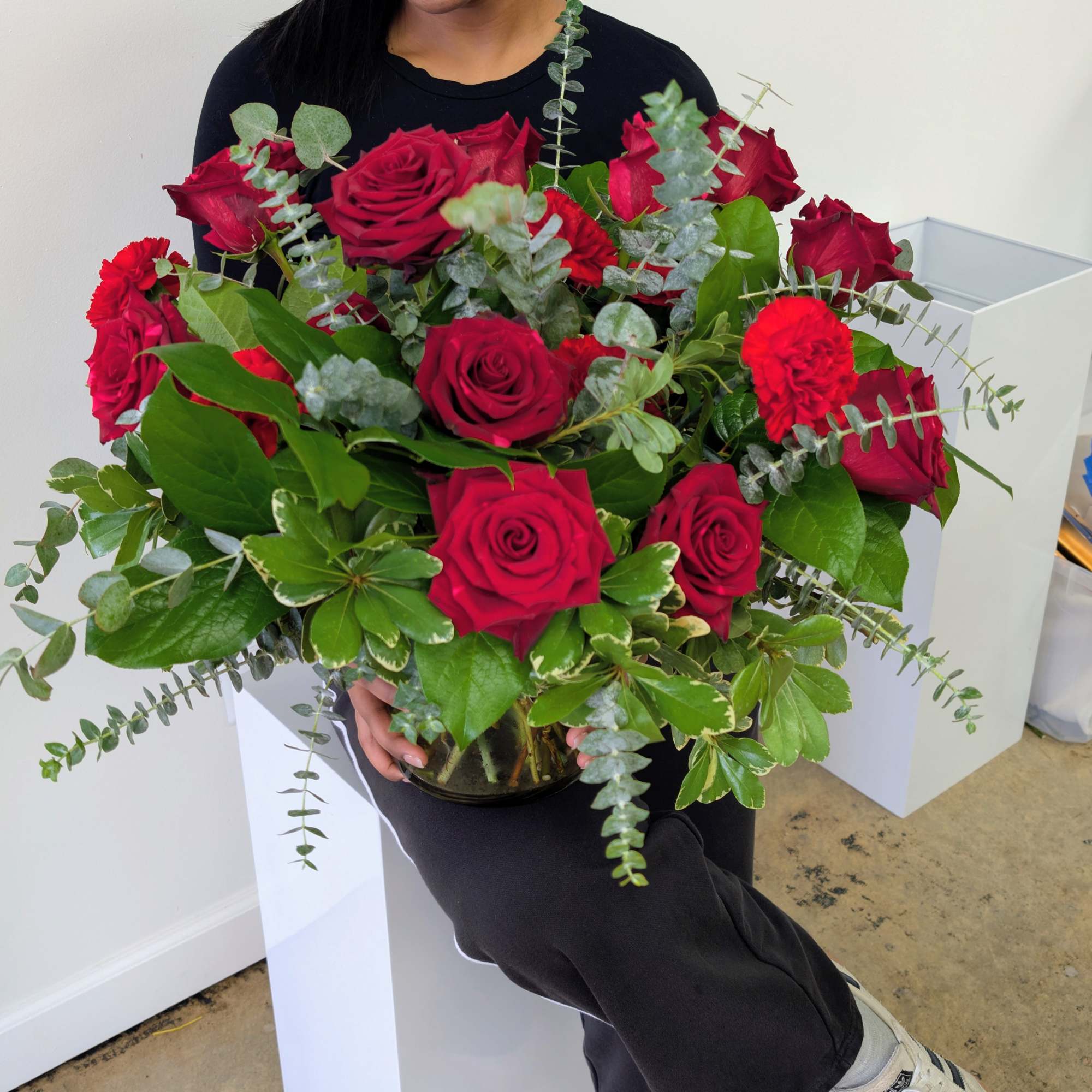 Bouquet of red roses with eucalyptus in a glass vase