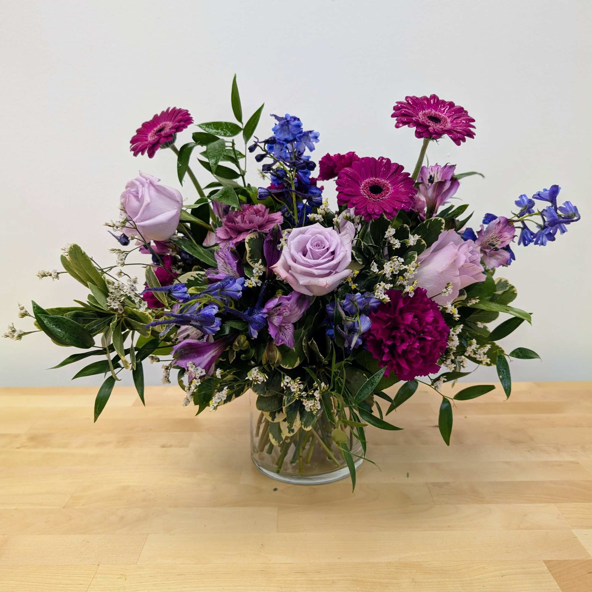 Mixed purple bouquet in a clear glass vase