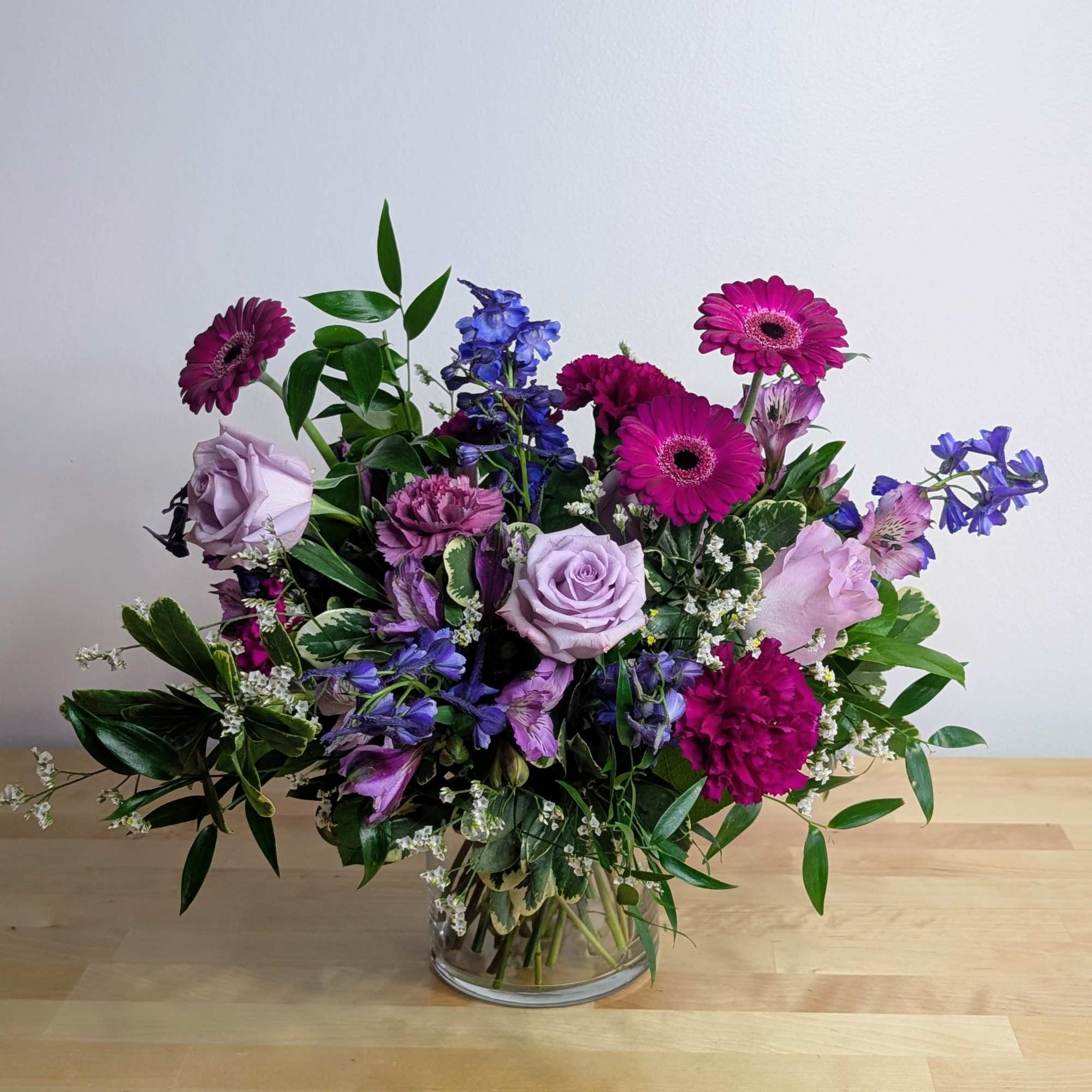 Mixed bouquet of purple and pink flowers in a glass vase
