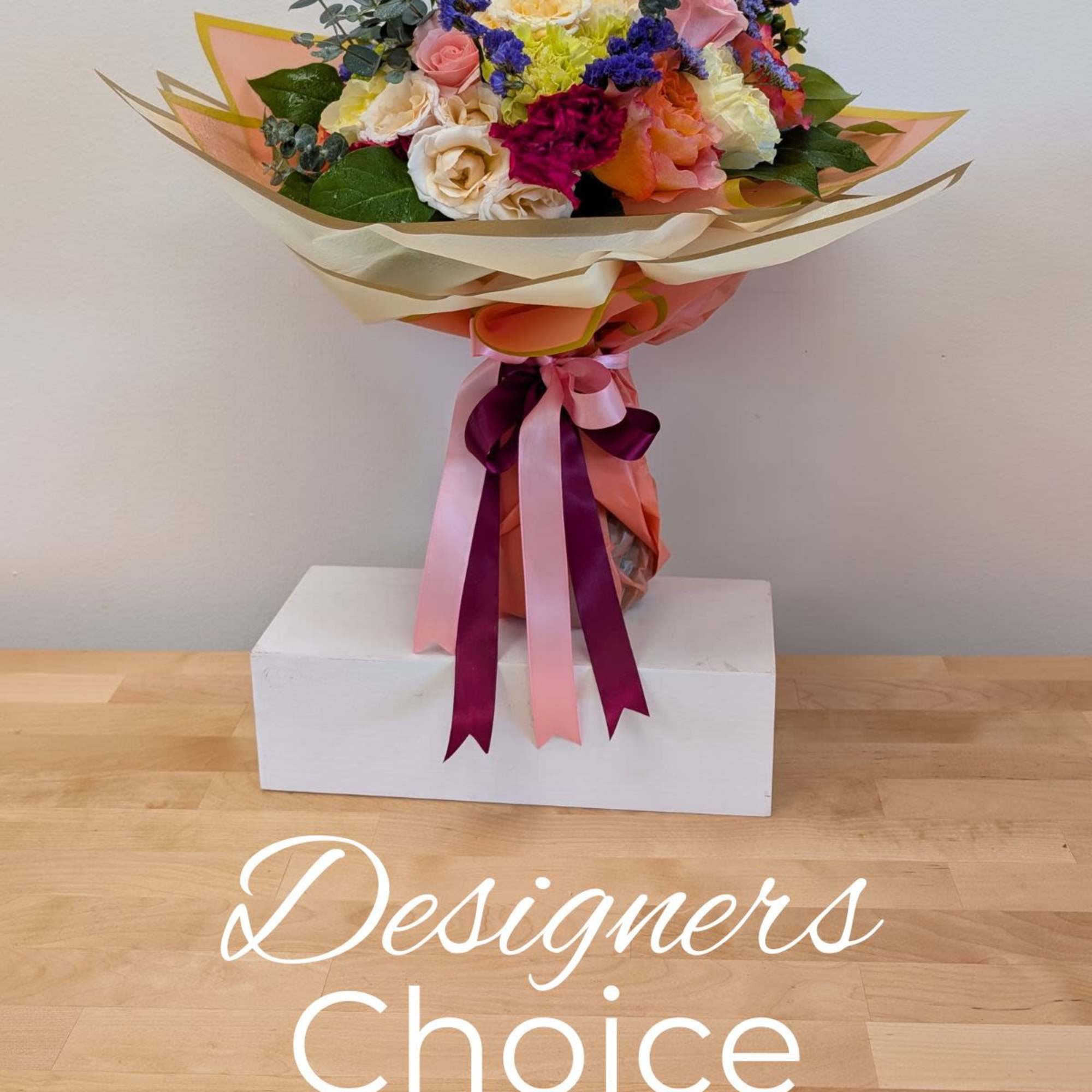 Mixed bouquet of roses and carnations wrapped with pink and cream paper
