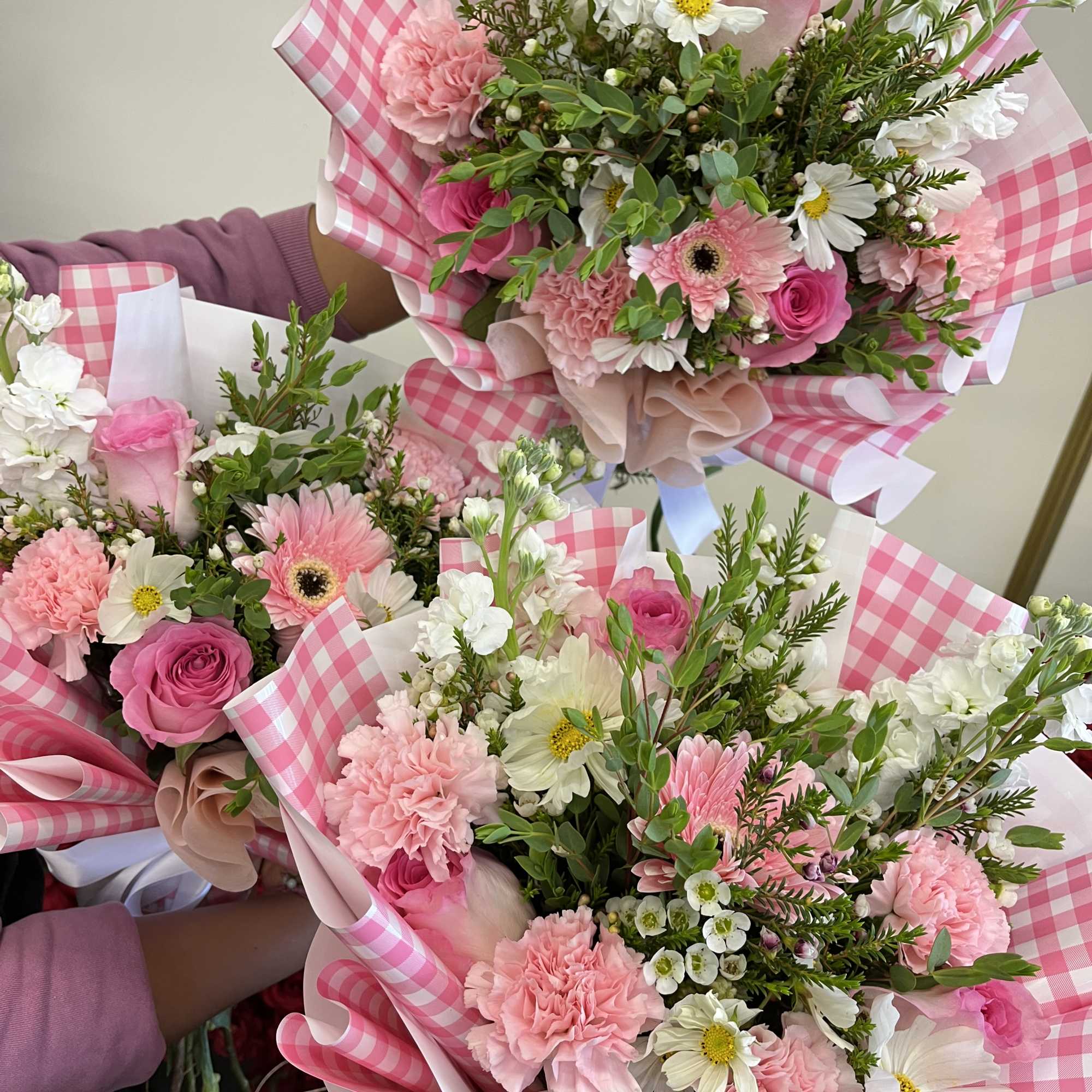 Pink and white mixed bouquets wrapped in pink gingham paper