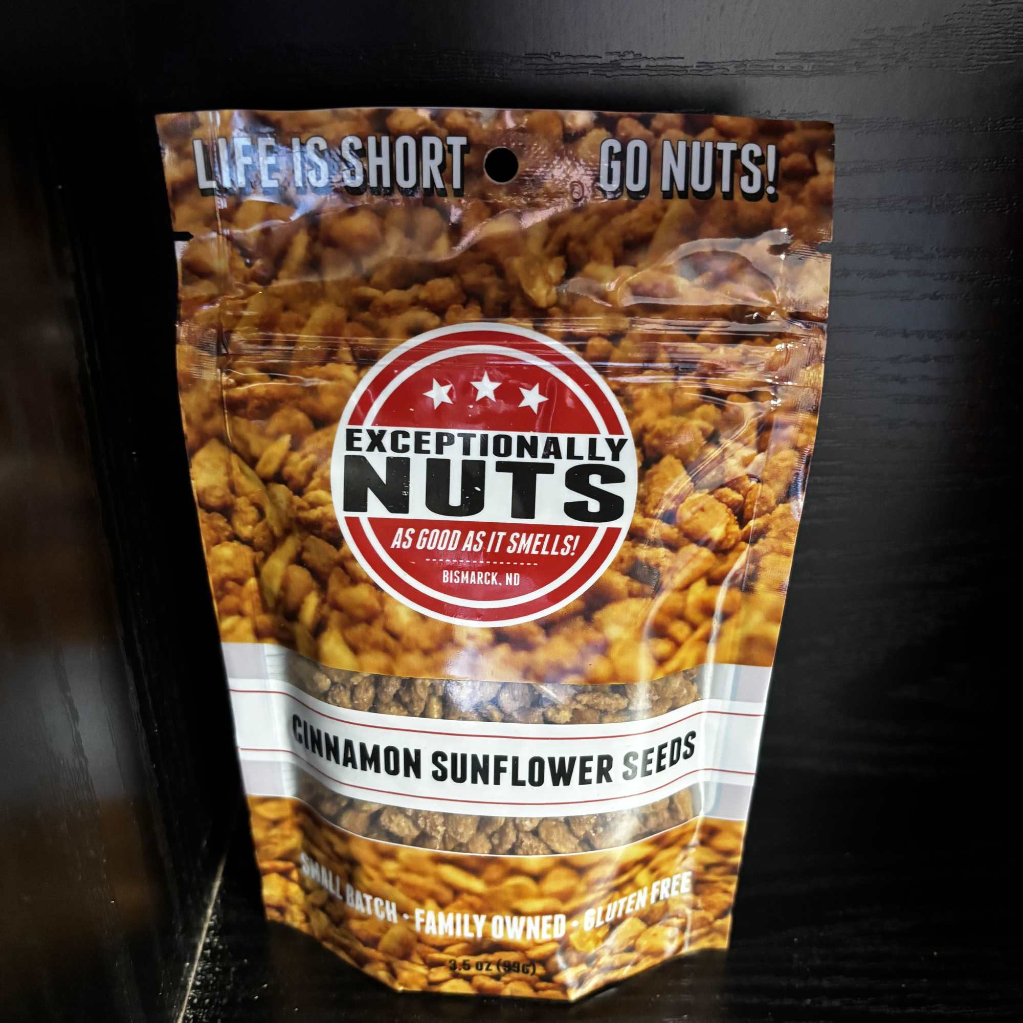 Bag of cinnamon sunflower seeds on a dark shelf