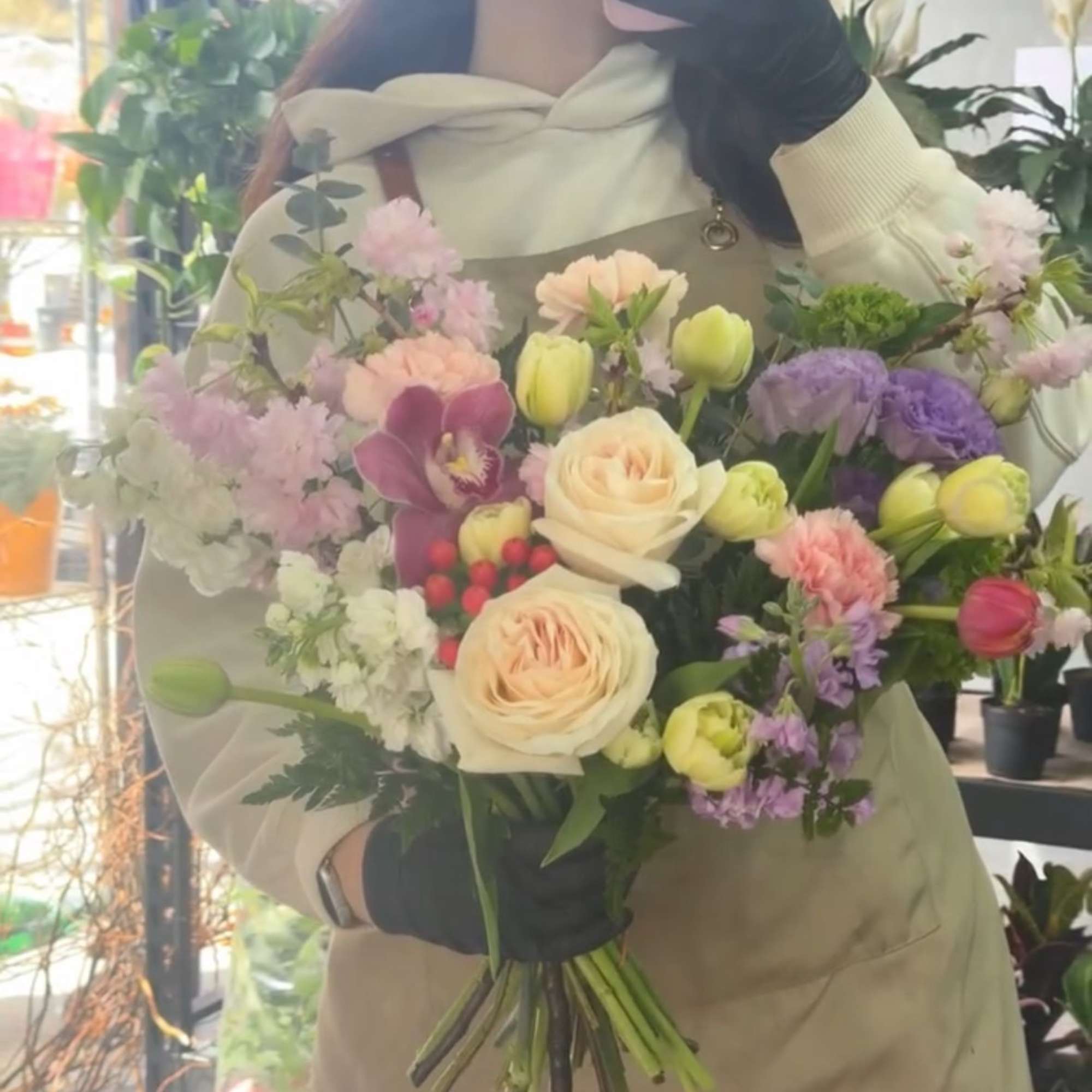 Mixed bouquet of pastel roses, orchids, and carnations