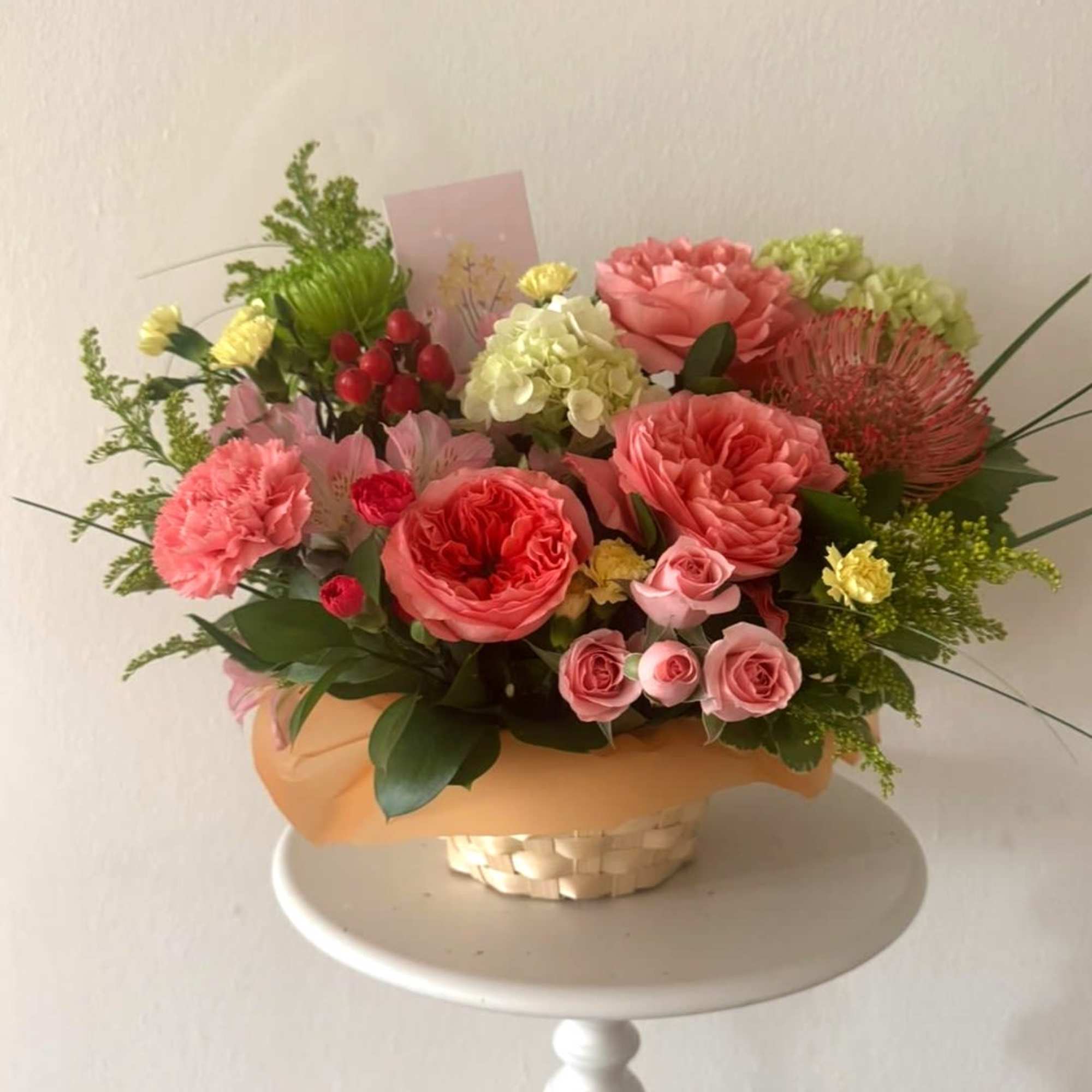 Bright mx of flowers in a basket. Garden rose, Chrysanthemum, Solidago, Hydrangea.