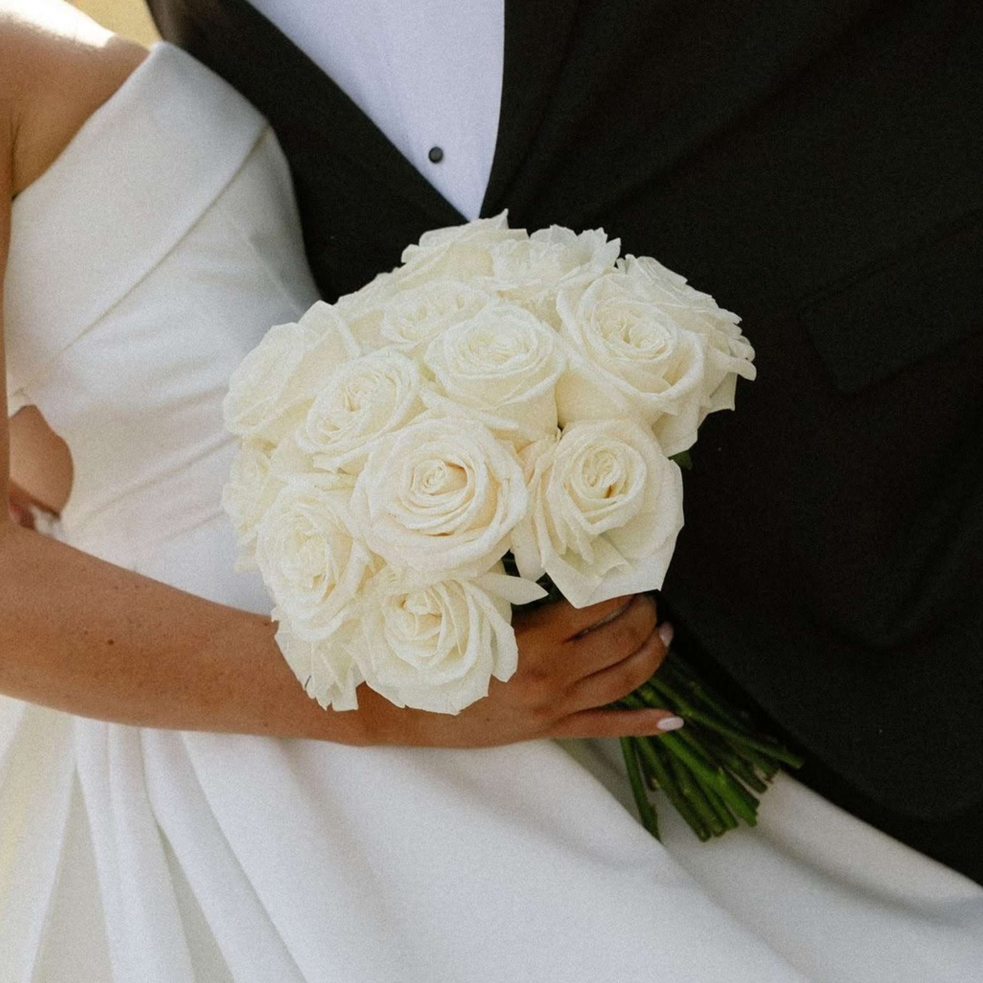 Bride holding a bouquet of white roses