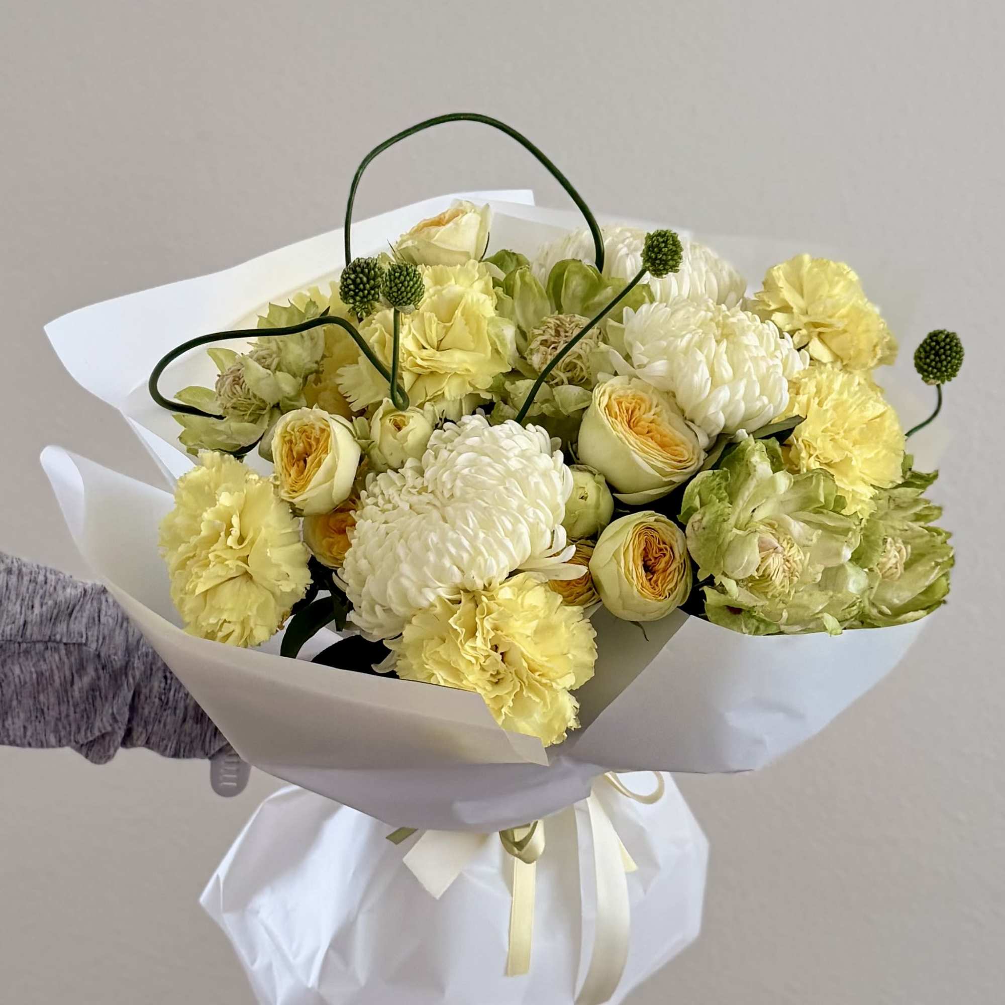 A fresh and elegant mix of garden roses, pots, and carnations in, photo 2 of 2