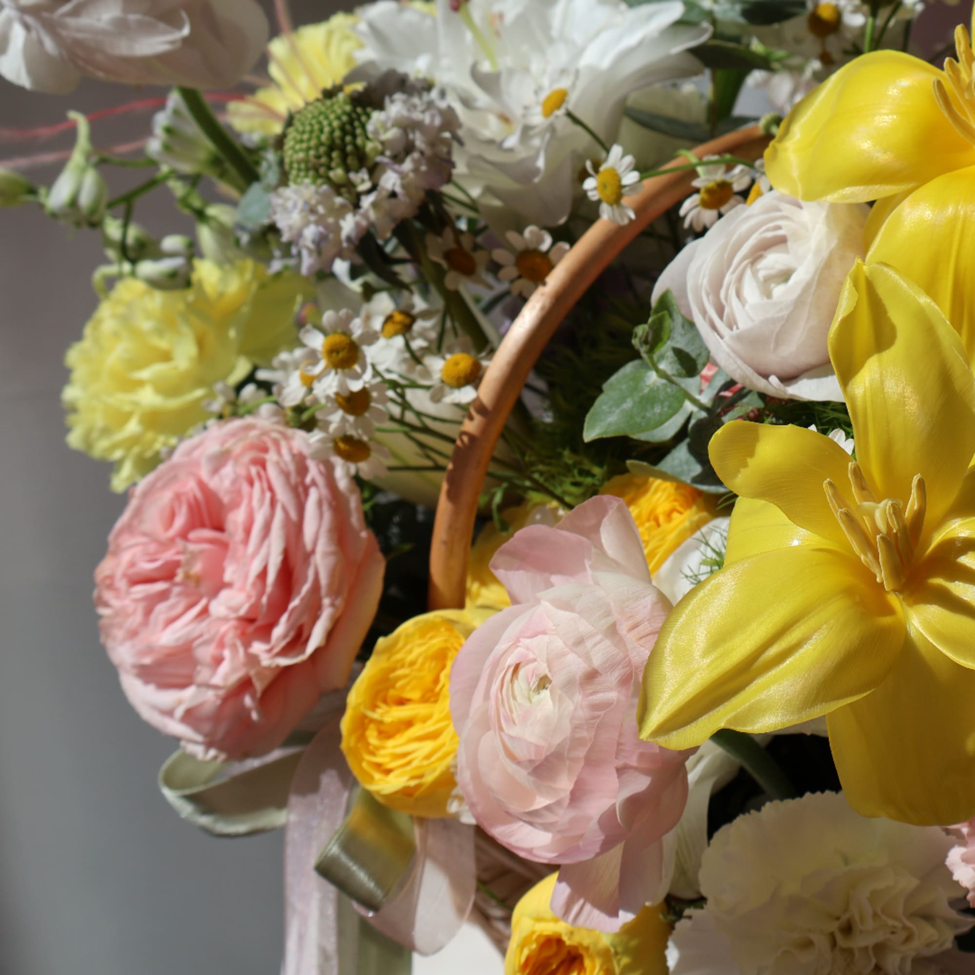 Mixed bouquet with pink, yellow, and white flowers in a basket