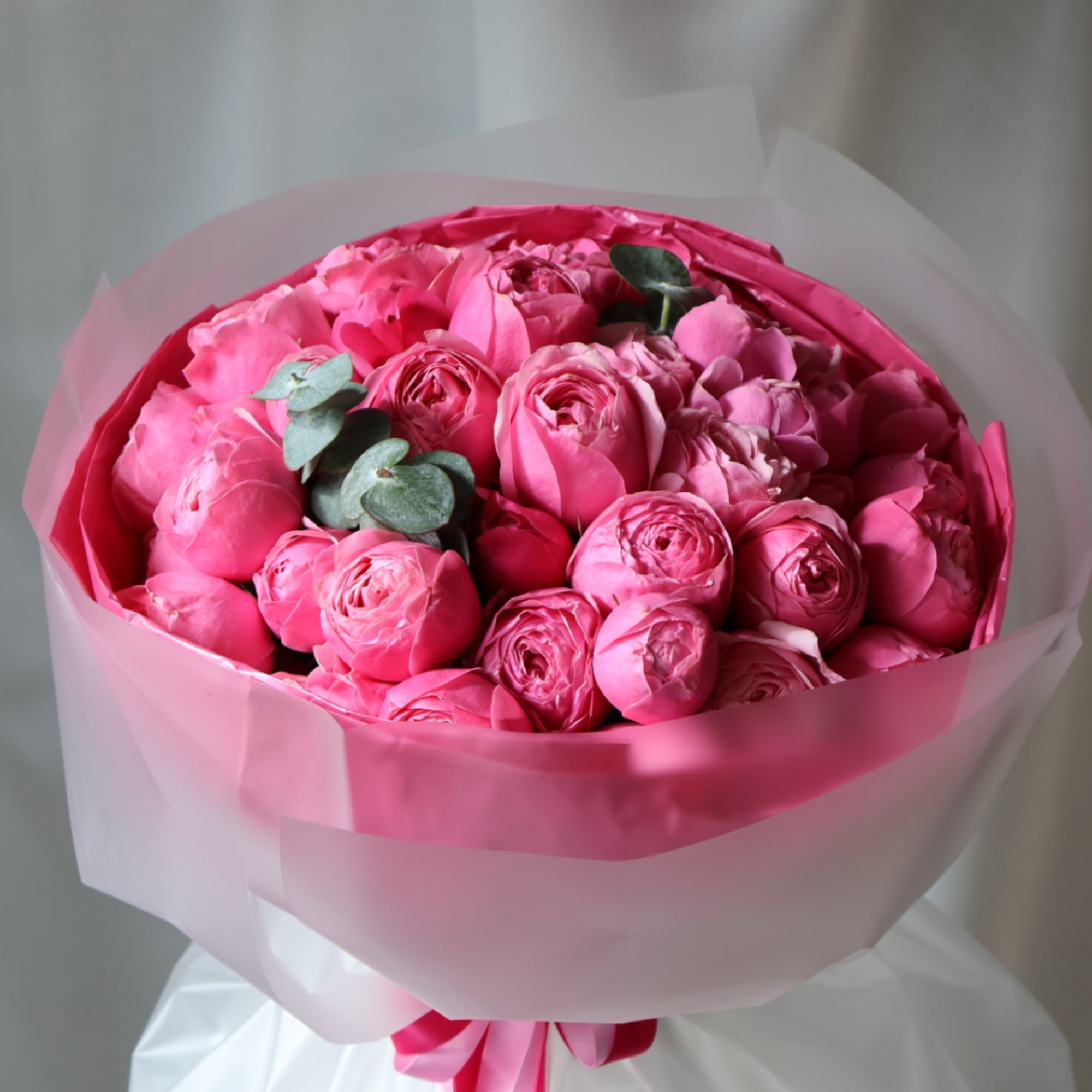 Bouquet of pink roses wrapped in translucent pink paper