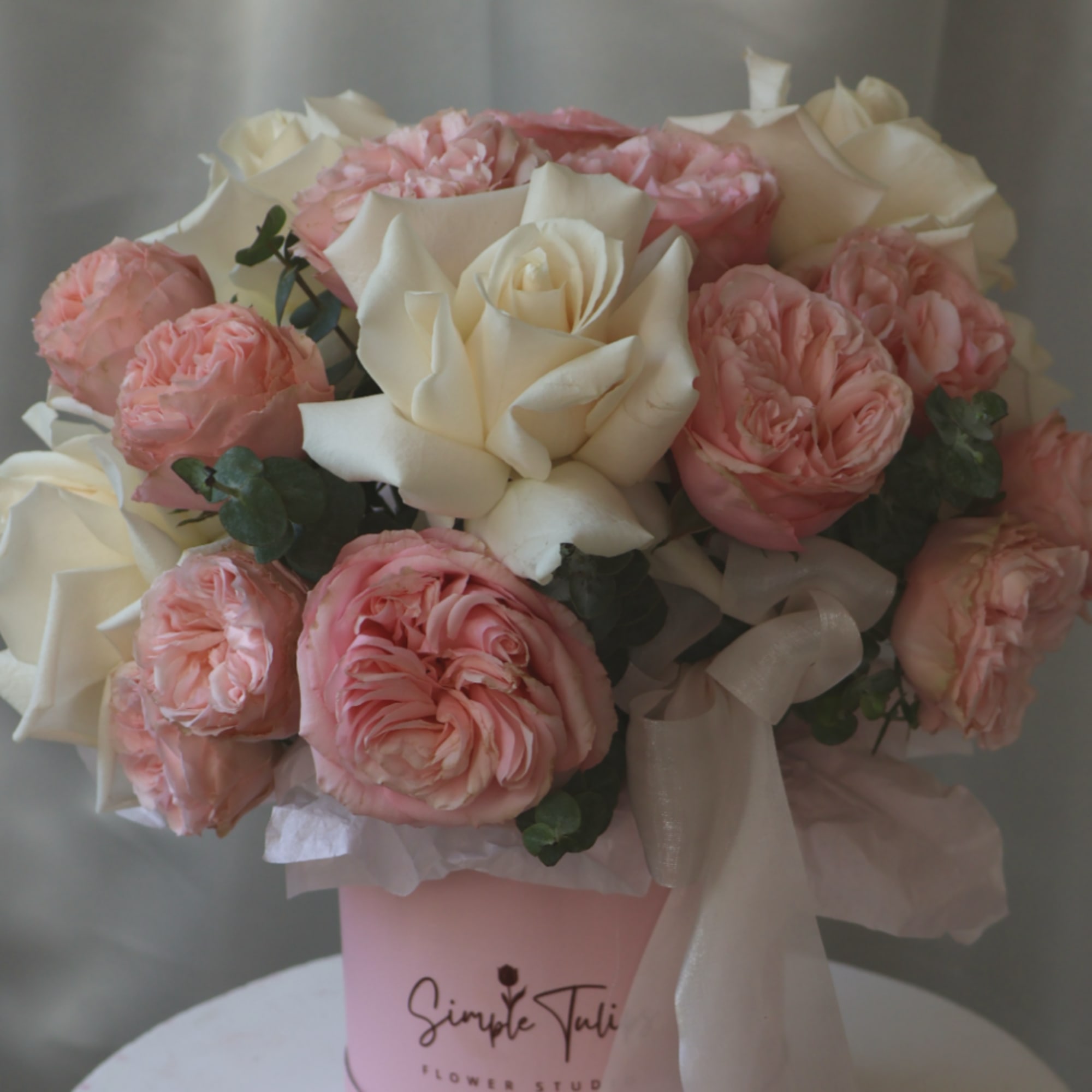 Pink and white rose bouquet in a pink box with a ribbon