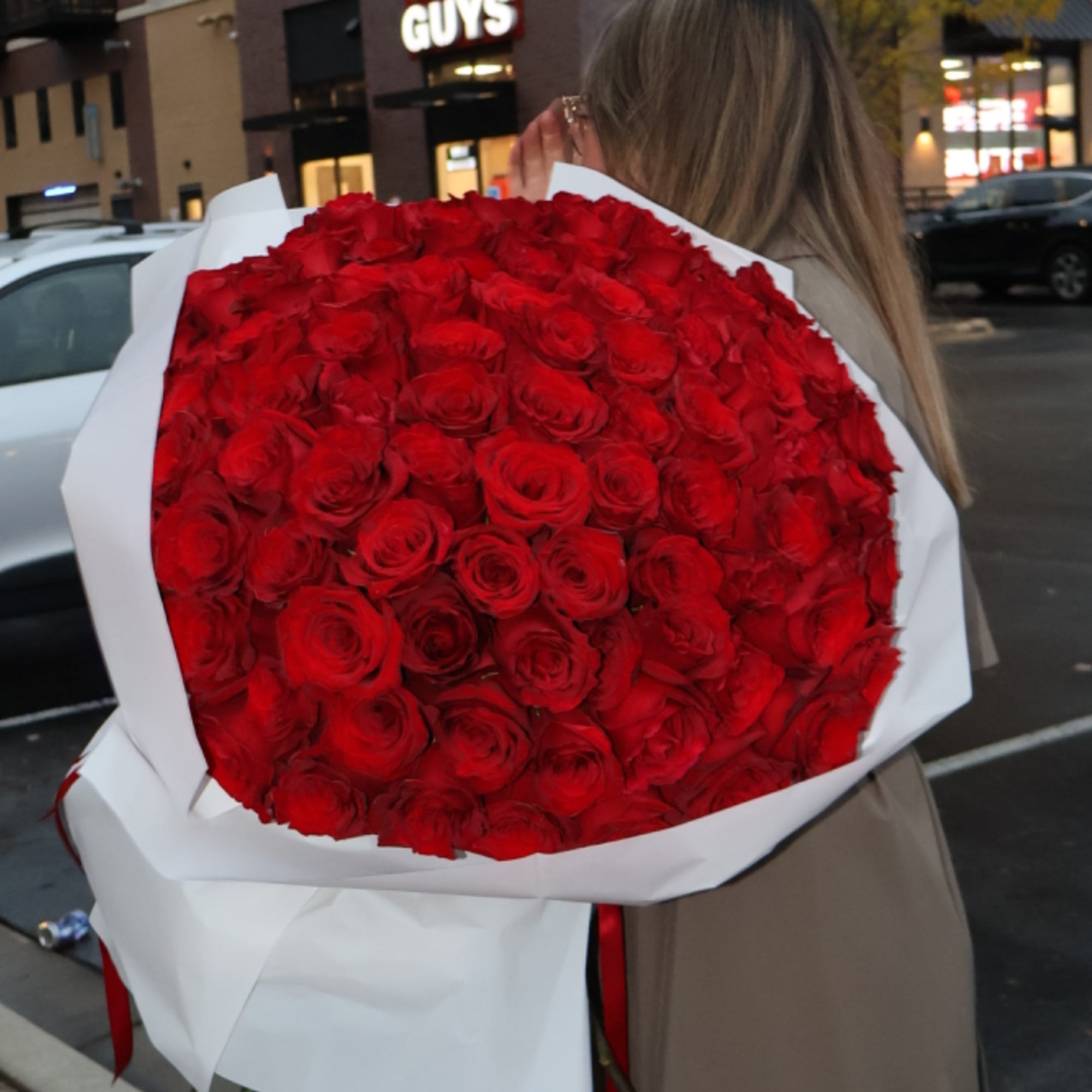 Large bouquet of red roses wrapped in white paper