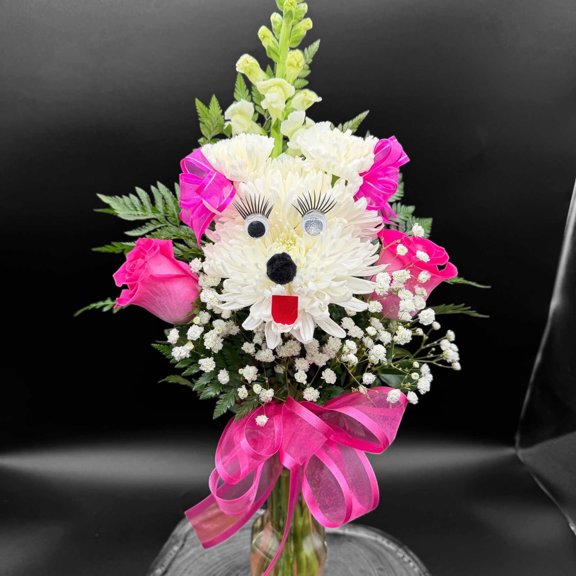 White chrysanthemum bouquet with pink roses and a bright ribbon in a glass vase