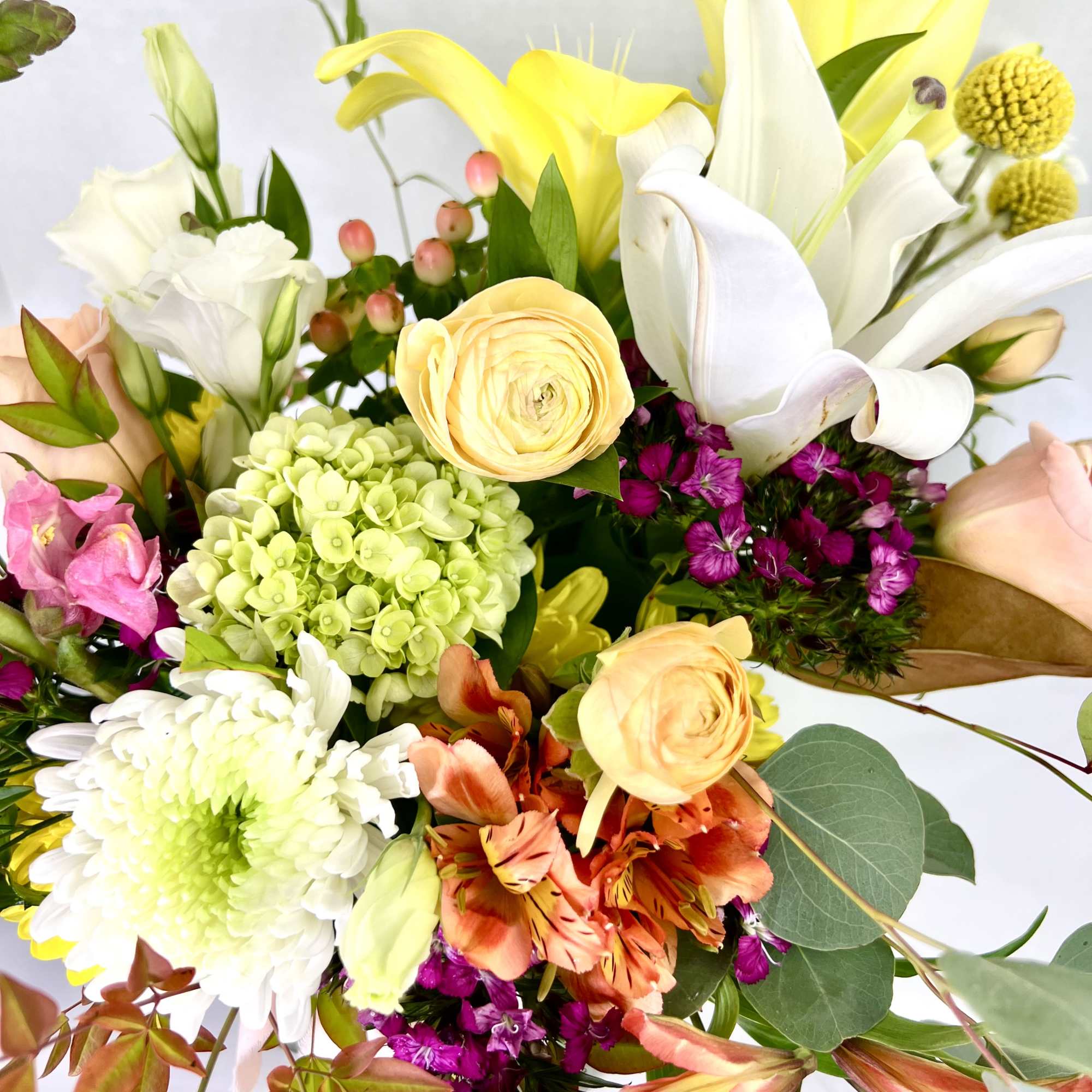 Mixed bouquet with yellow lilies, white calla lilies, and pastel roses