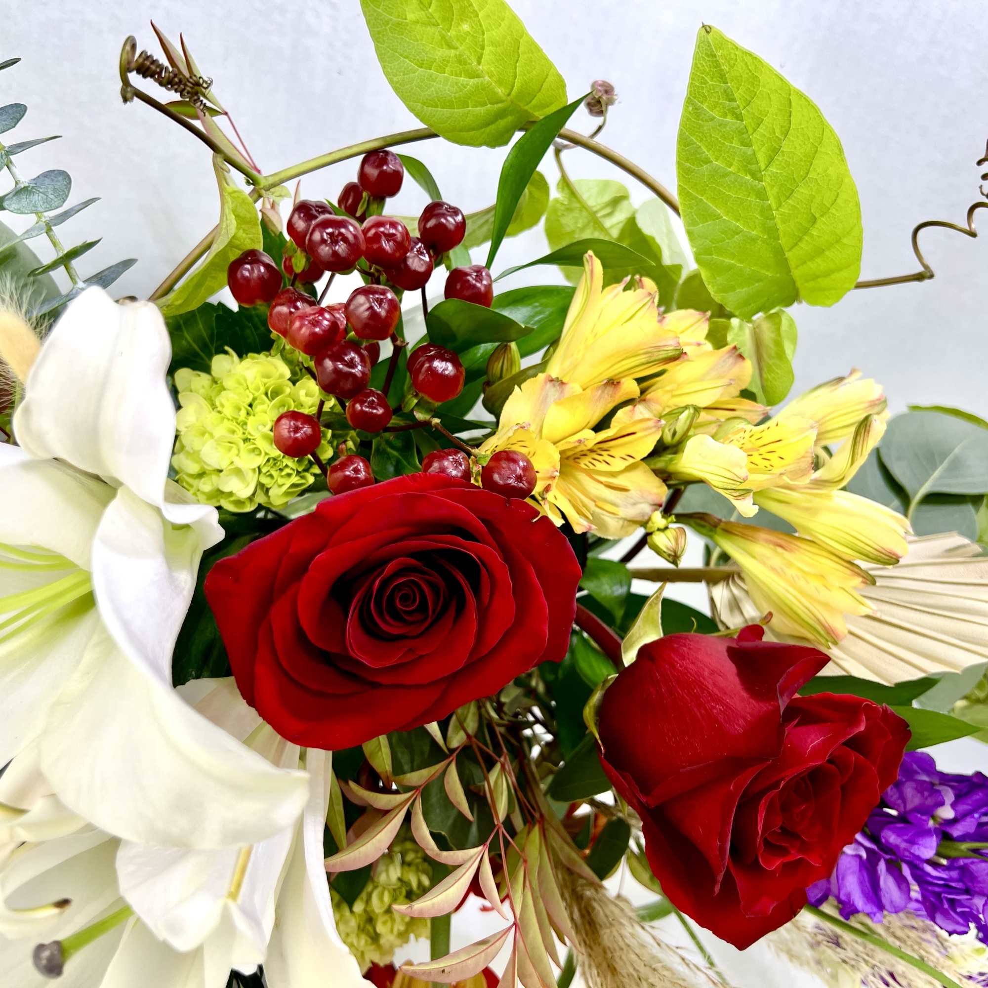 Mixed bouquet with red roses, white lilies, and yellow flowers