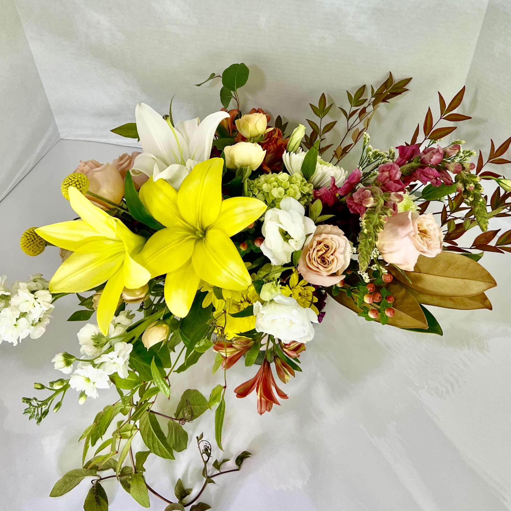 Mixed bouquet with yellow lilies, white lilies, roses, and pink flowers