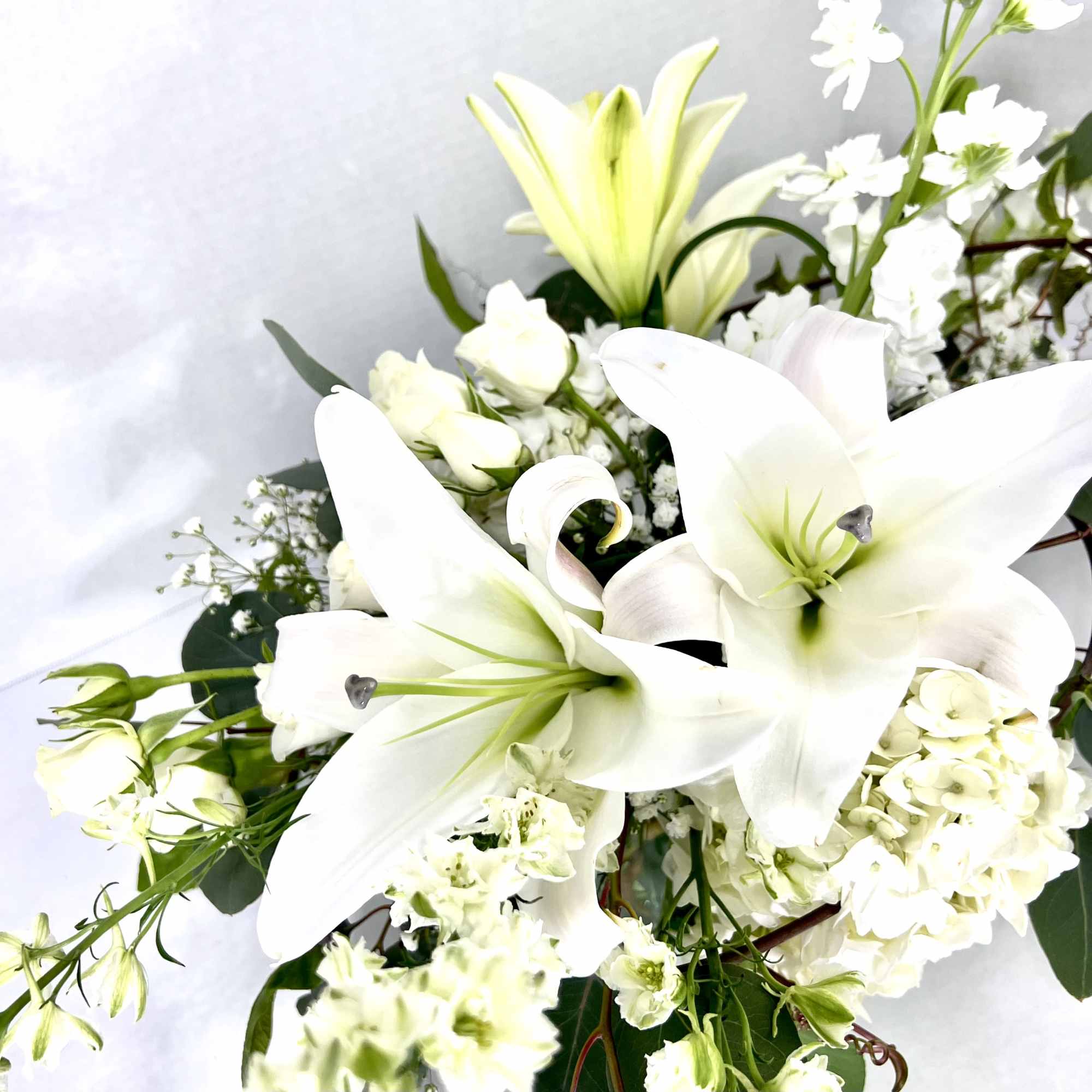 White lilies and small white flowers in a bouquet