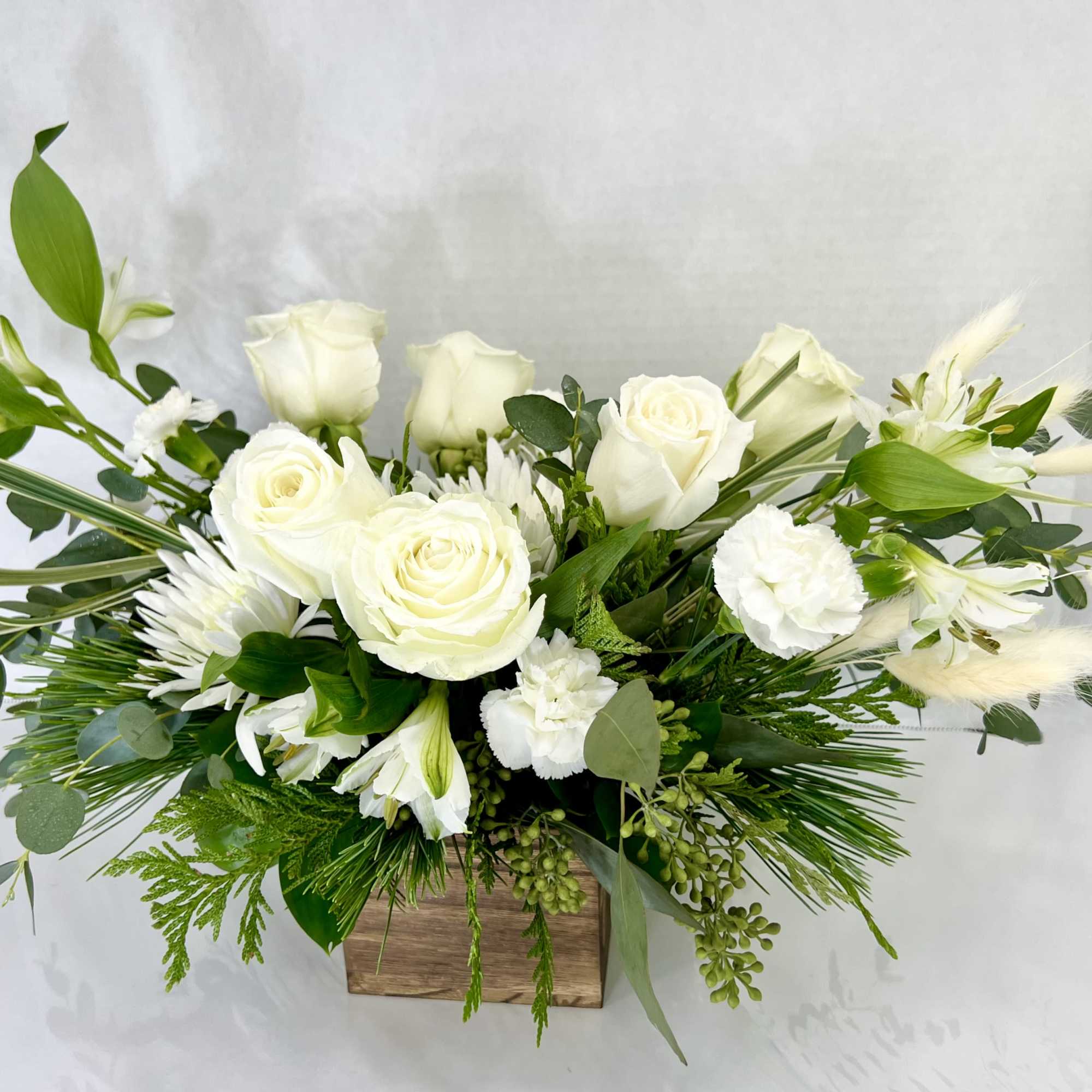 White roses and mixed white flowers in a wooden box arrangement