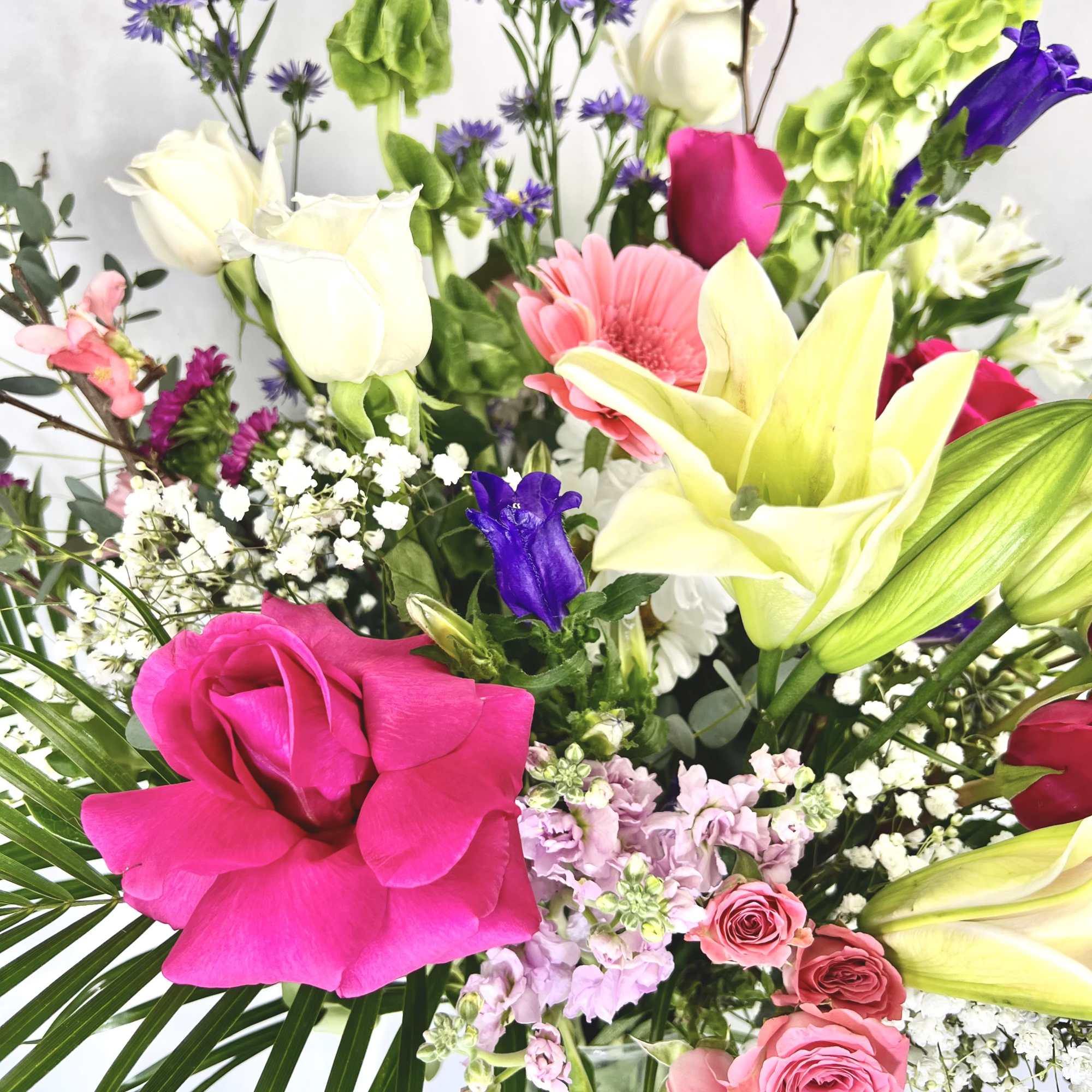 This arrangement contains stargazer lilies, bells of ireland, stock, blue iris, roses, photo 2 of 2