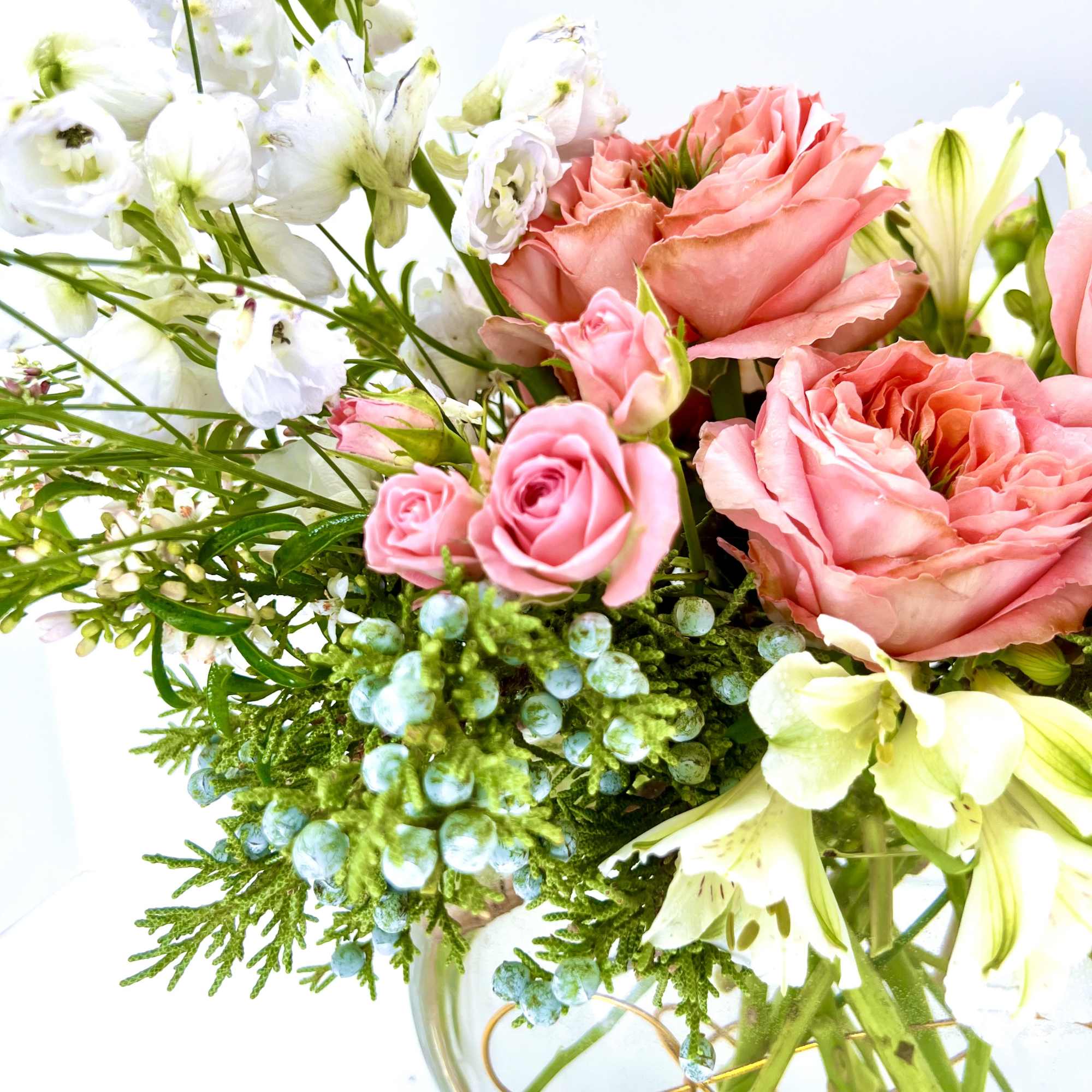 Pink roses and white lilies in a clear glass vase