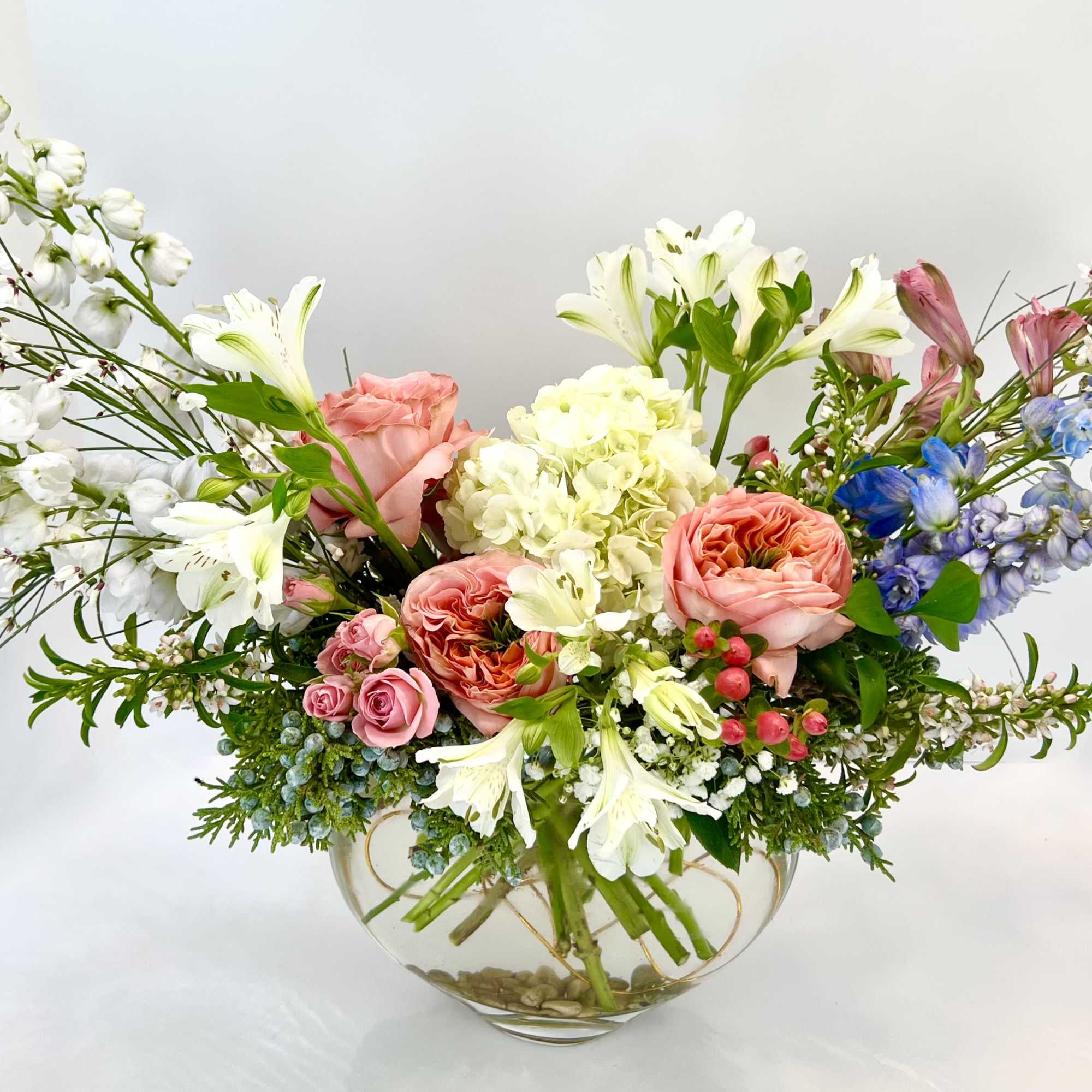 Mixed bouquet of pink and white flowers in a glass bowl vase