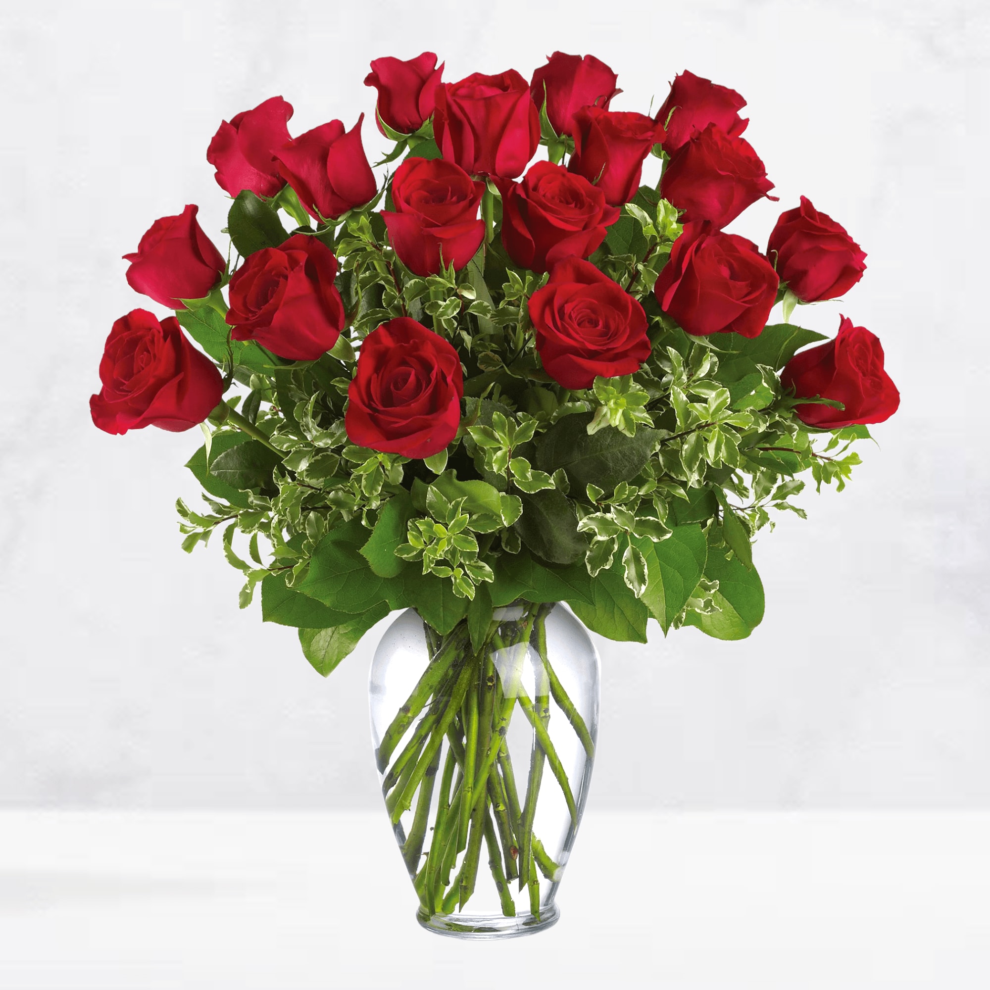 Red roses arranged in a clear glass vase