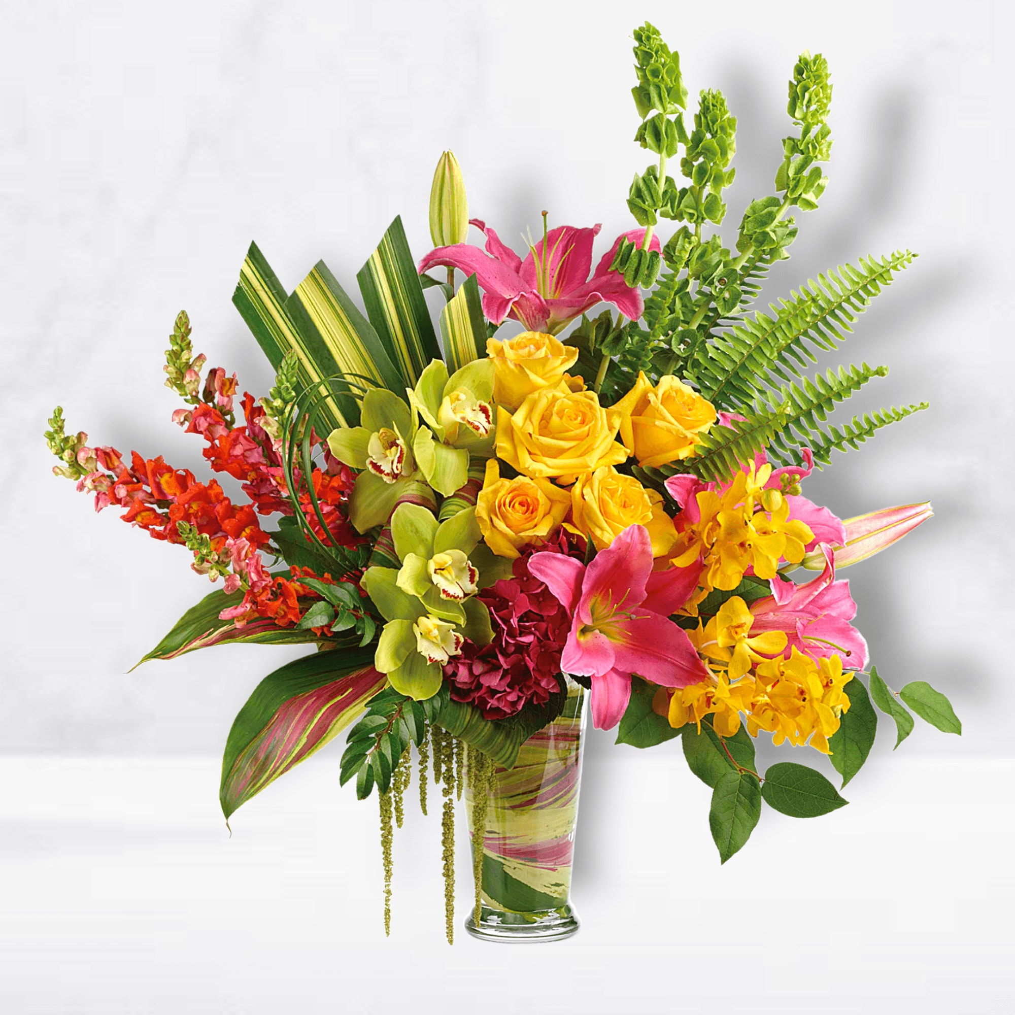 Bright mixed bouquet with roses, lilies, and orchids in a glass vase