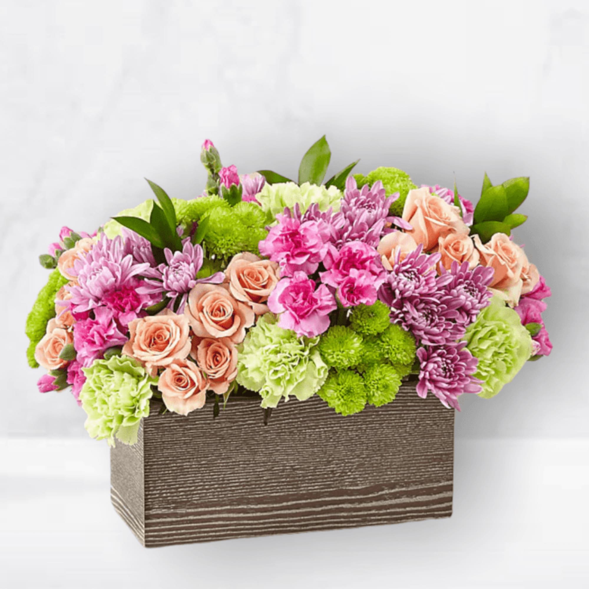 Mixed pink and green floral arrangement in a rectangular wooden box
