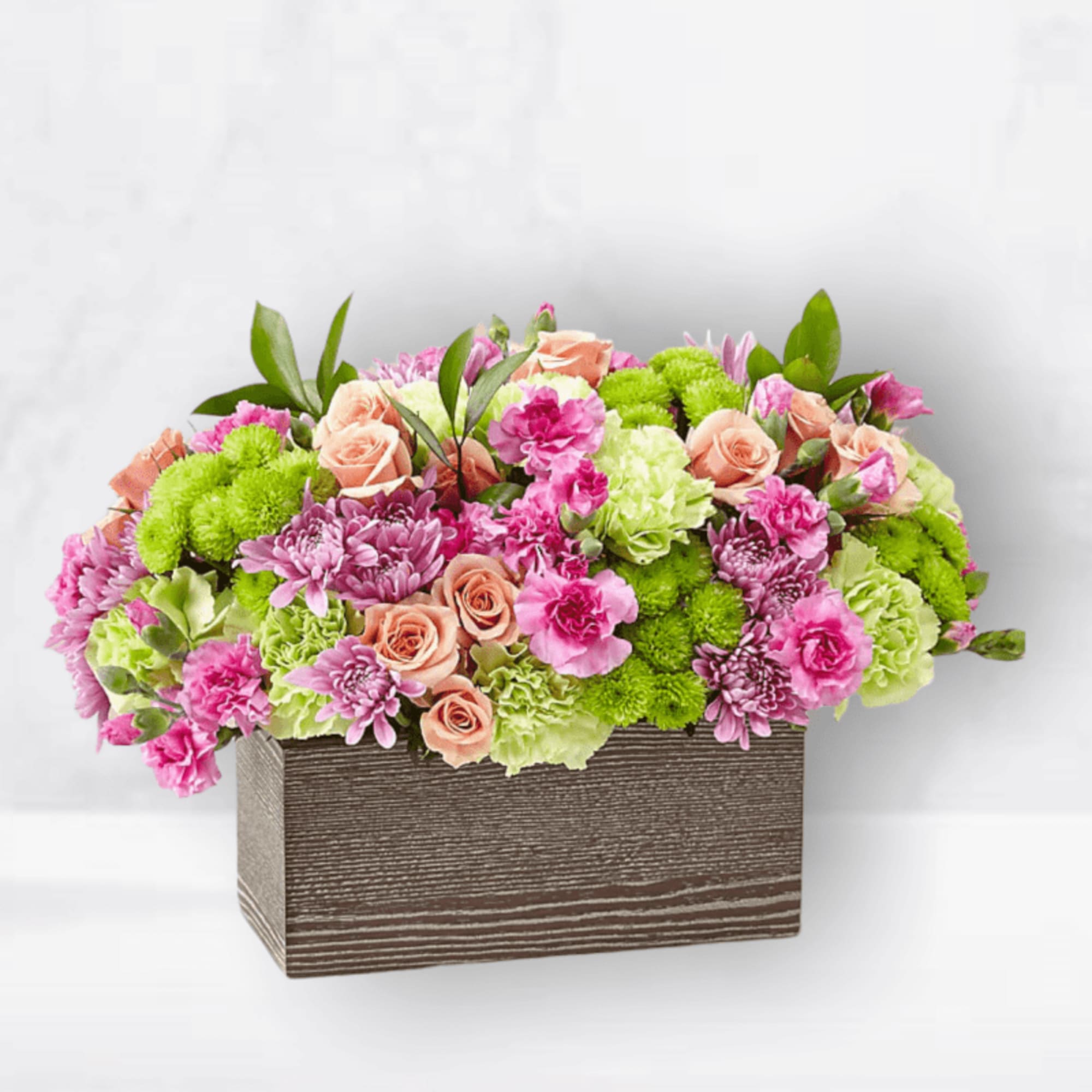 Pink and green floral arrangement in a rectangular wooden box