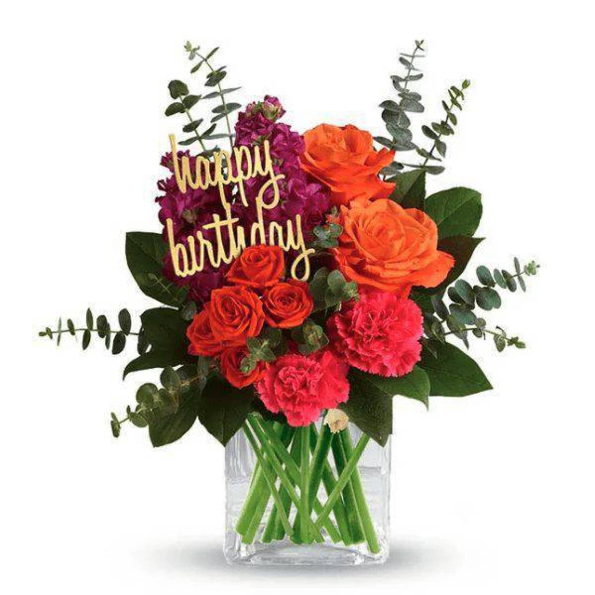 Birthday bouquet of orange and pink flowers in a clear vase