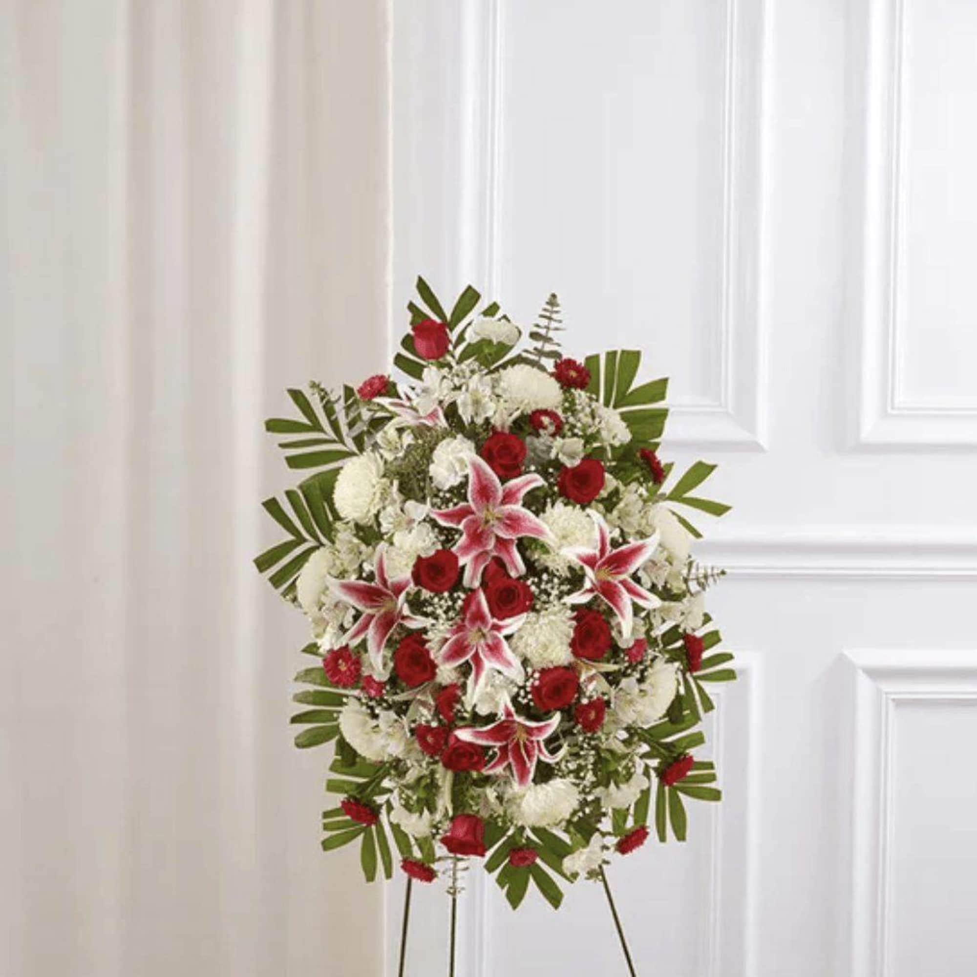Standing floral spray with red and white flowers on an easel