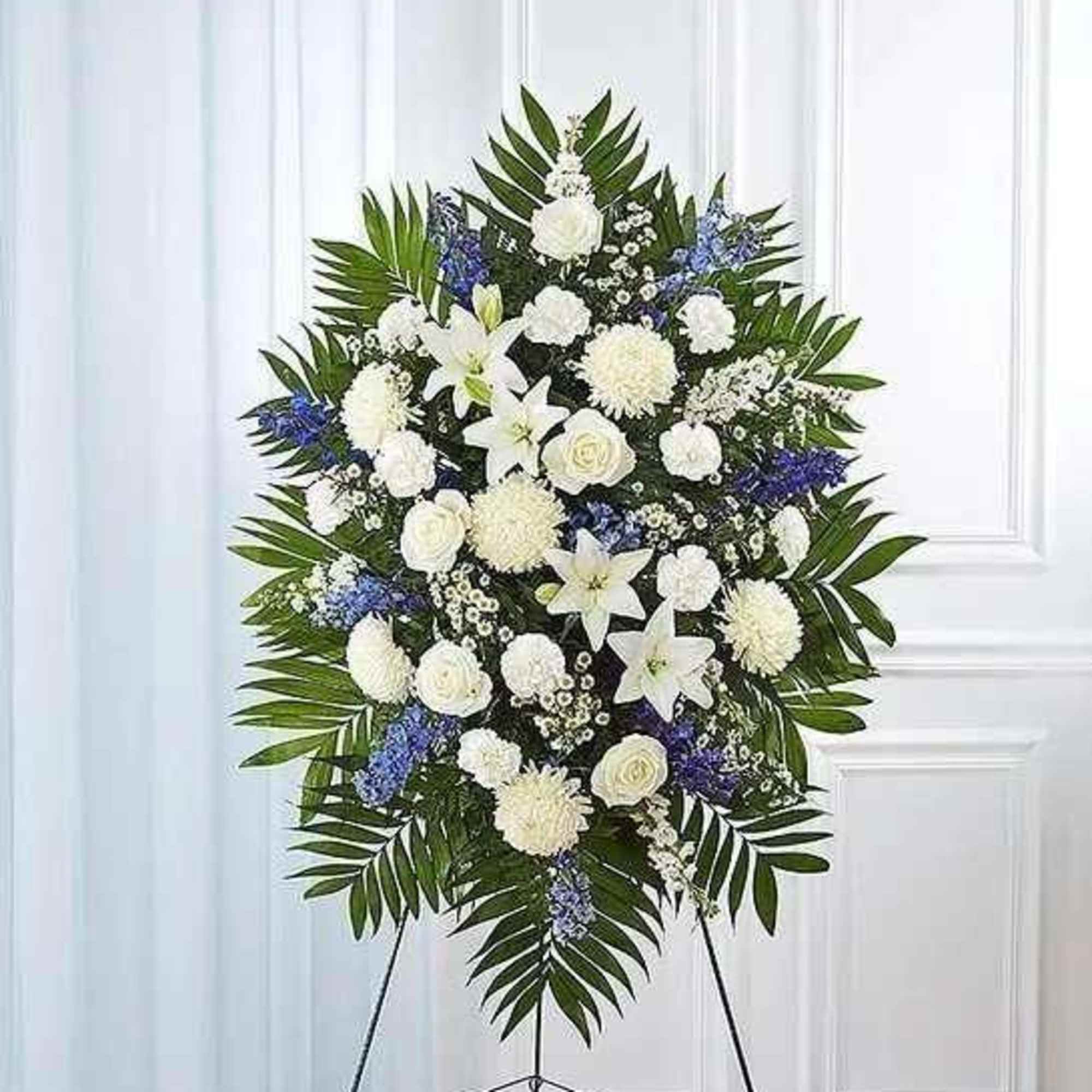 White and blue funeral spray on a standing easel