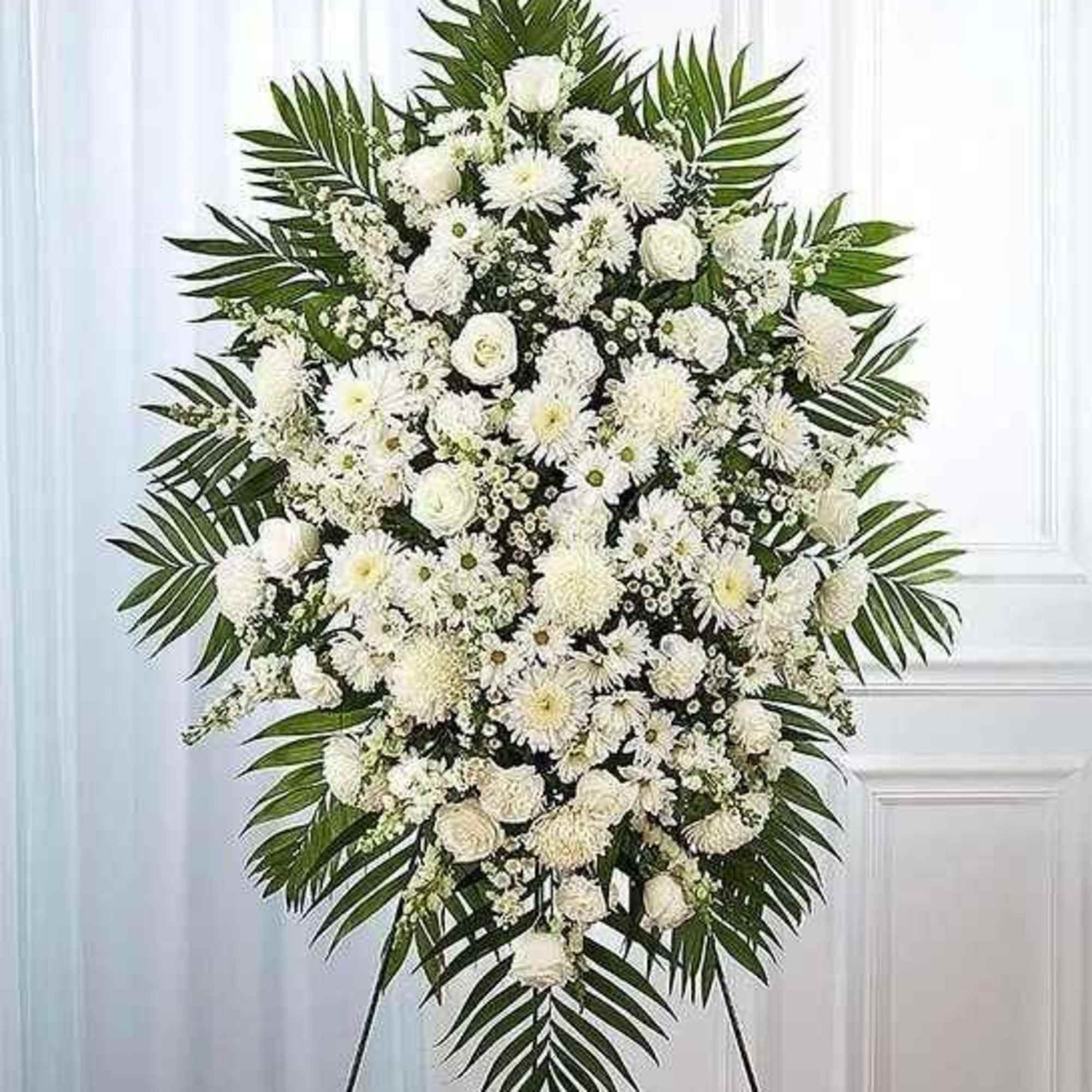 Large white funeral spray with palm fronds on a stand