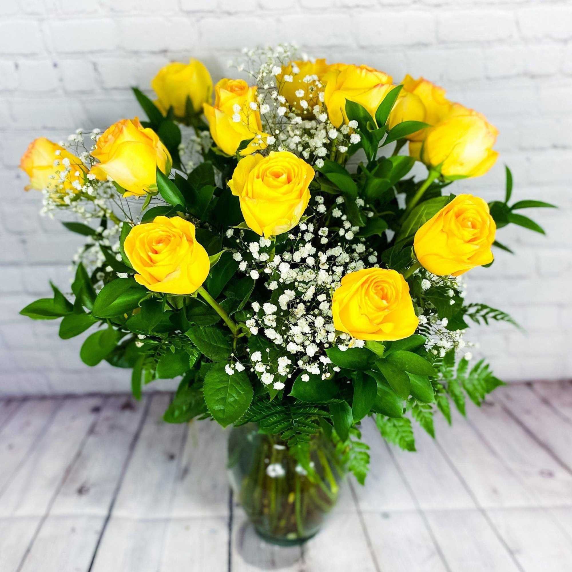 Yellow roses with baby's breath in a glass vase
